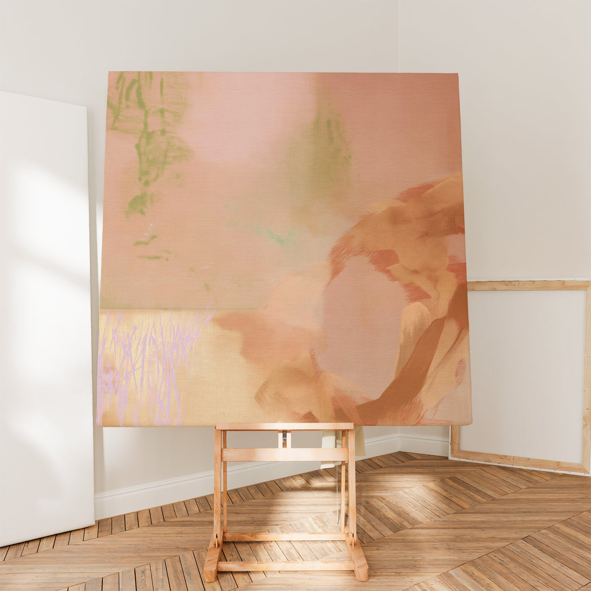 Square abstract canvas in peach, terracotta and sage displayed on a wooden easel in a sunlit studio.