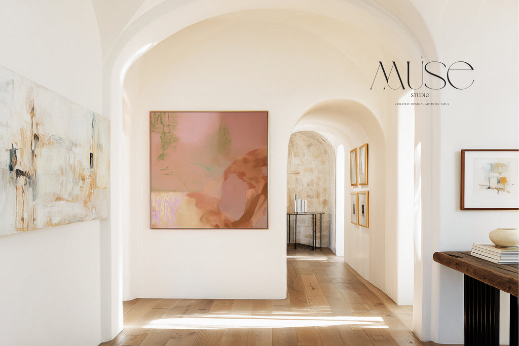 Framed terracotta and sage abstract wall art viewed through an archway in a bright hallway with wood floors