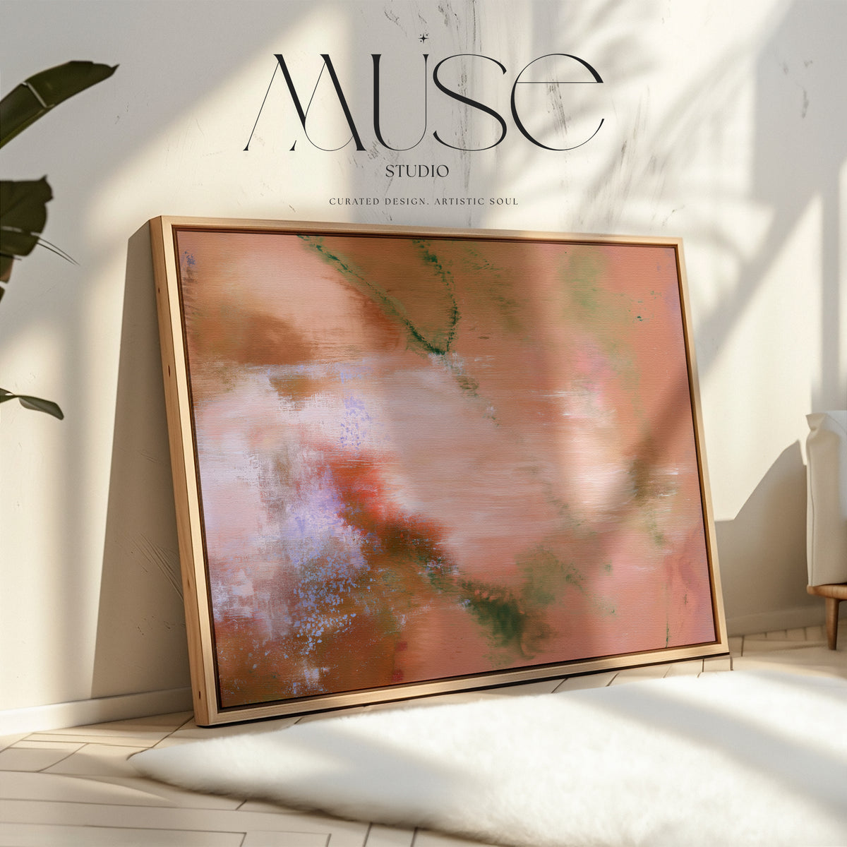 Framed earthy abstract wall art leaning on the floor against a neutral wall with natural window sunlight shadows and white rug.