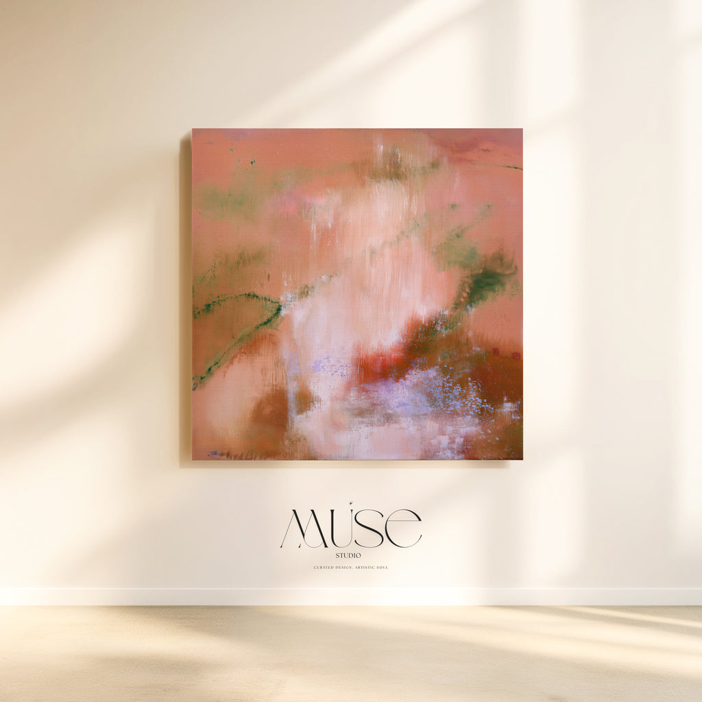 An abstract square canvas painting in warm pink, peach, brown, and soft green tones hanging on a cream wall, with sunlight casting shadows and the Muse Studios logo below.
