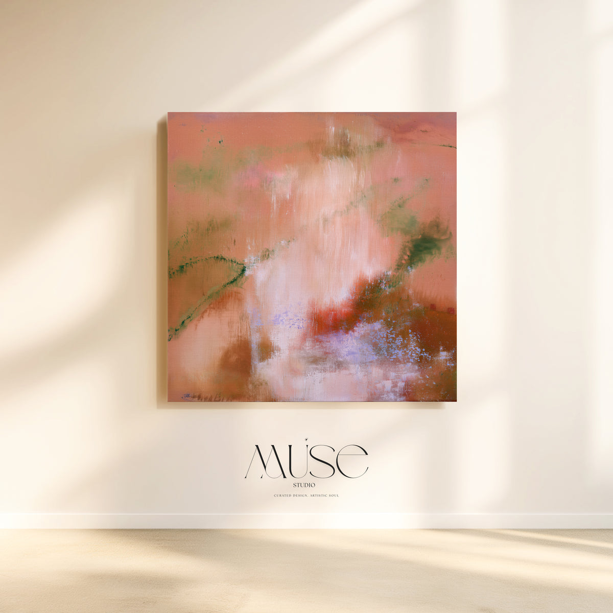 An abstract square canvas painting in warm pink, peach, brown, and soft green tones hanging on a cream wall, with sunlight casting shadows and the Muse Studios logo below.