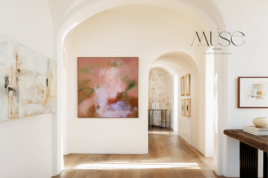 Framed square terracotta abstract wall art centered at the end of a plaster archway corridor with light oak floors and a rustic wooden console table.