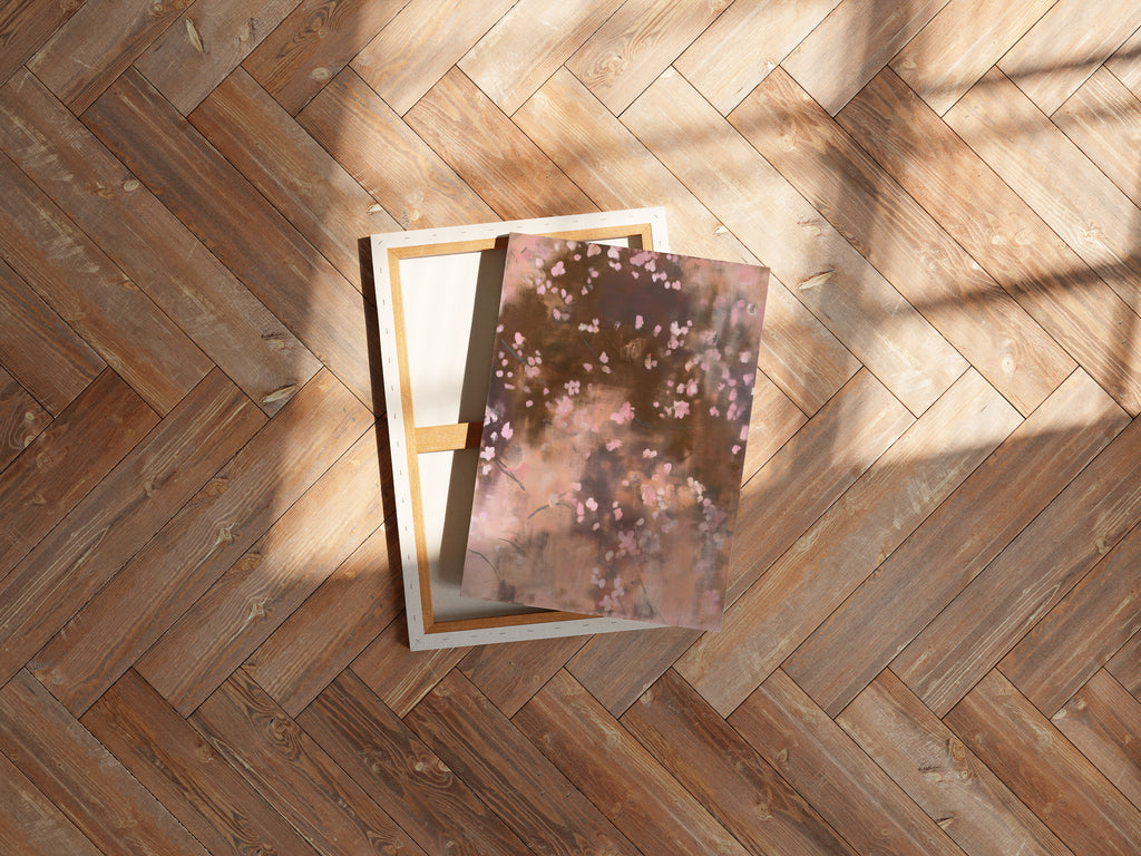 An overhead flat lay shot of the Dawn Nocturne No. 1123 gallery-wrapped canvas and its empty stretcher frame resting at an angle on a rustic wooden plank floor with bright sunlight.