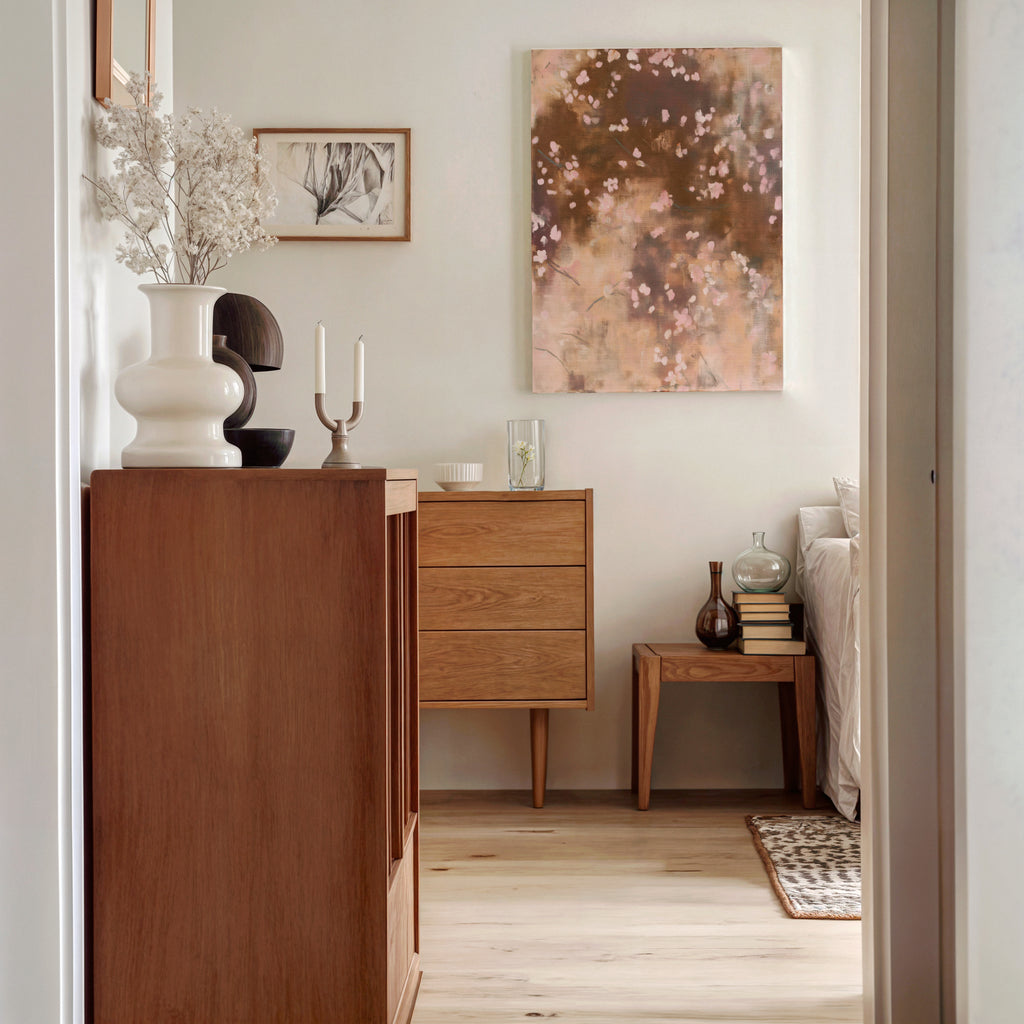 The Dawn Nocturne No. 1123 stretched canvas is displayed on a wall above modern wooden dressers in a bright bedroom, next to a vase of dried botanicals and books.