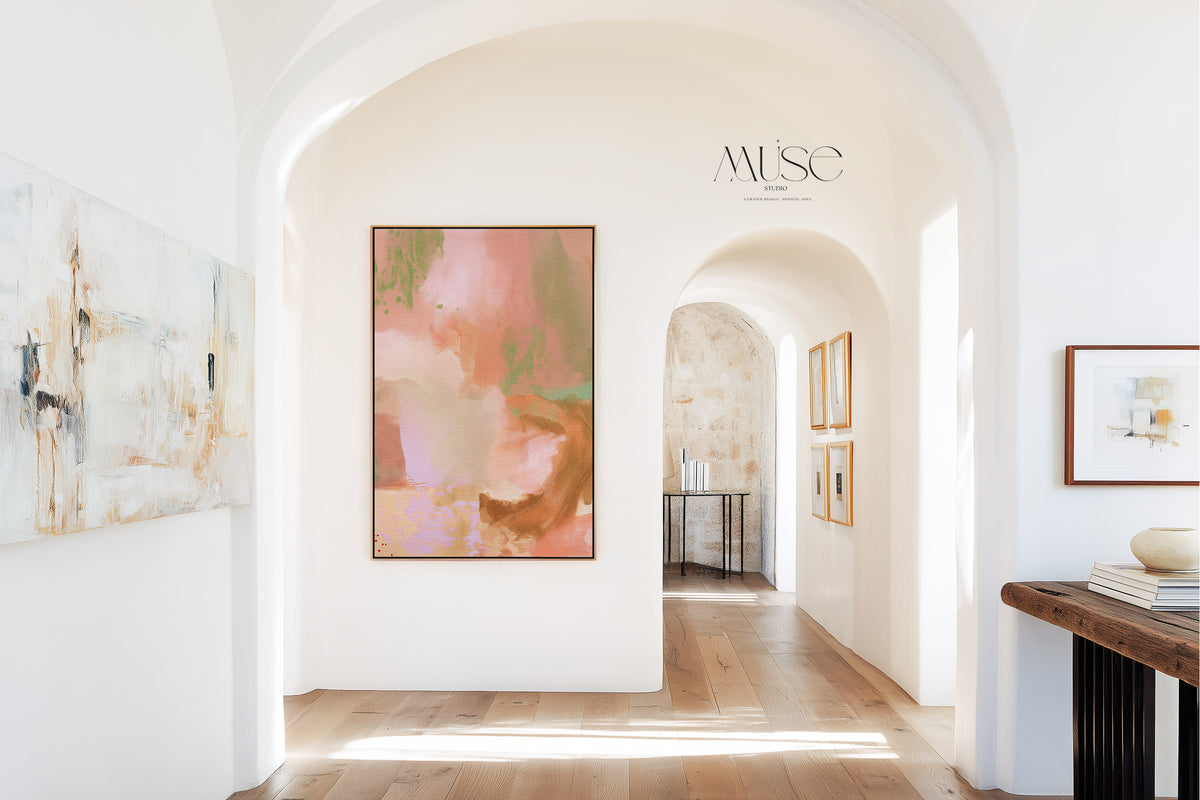 Bright, sunlit arched hallway in a modern Mediterranean home with light oak floors and smooth plaster walls, showcasing the vertical framed canvas print Gilded Meadow No. 1128.