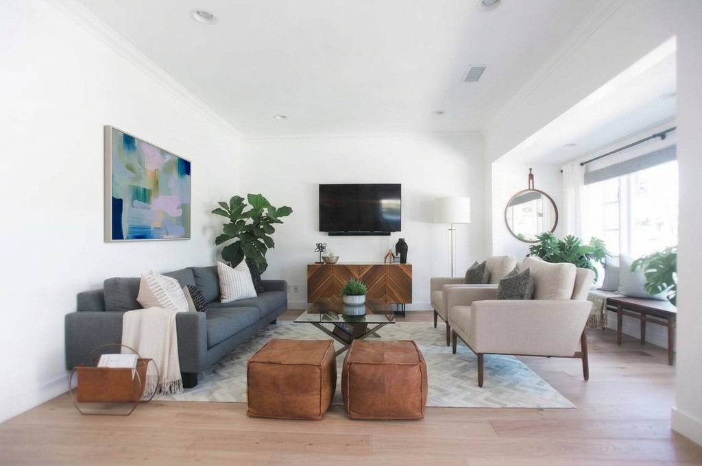 Pastel abstract canvas artwork by Muse Studio & Co. featuring brushstrokes of mint green, soft lavender, teal, and navy blue hanging above a dark grey sofa in a brightly lit modern living room.