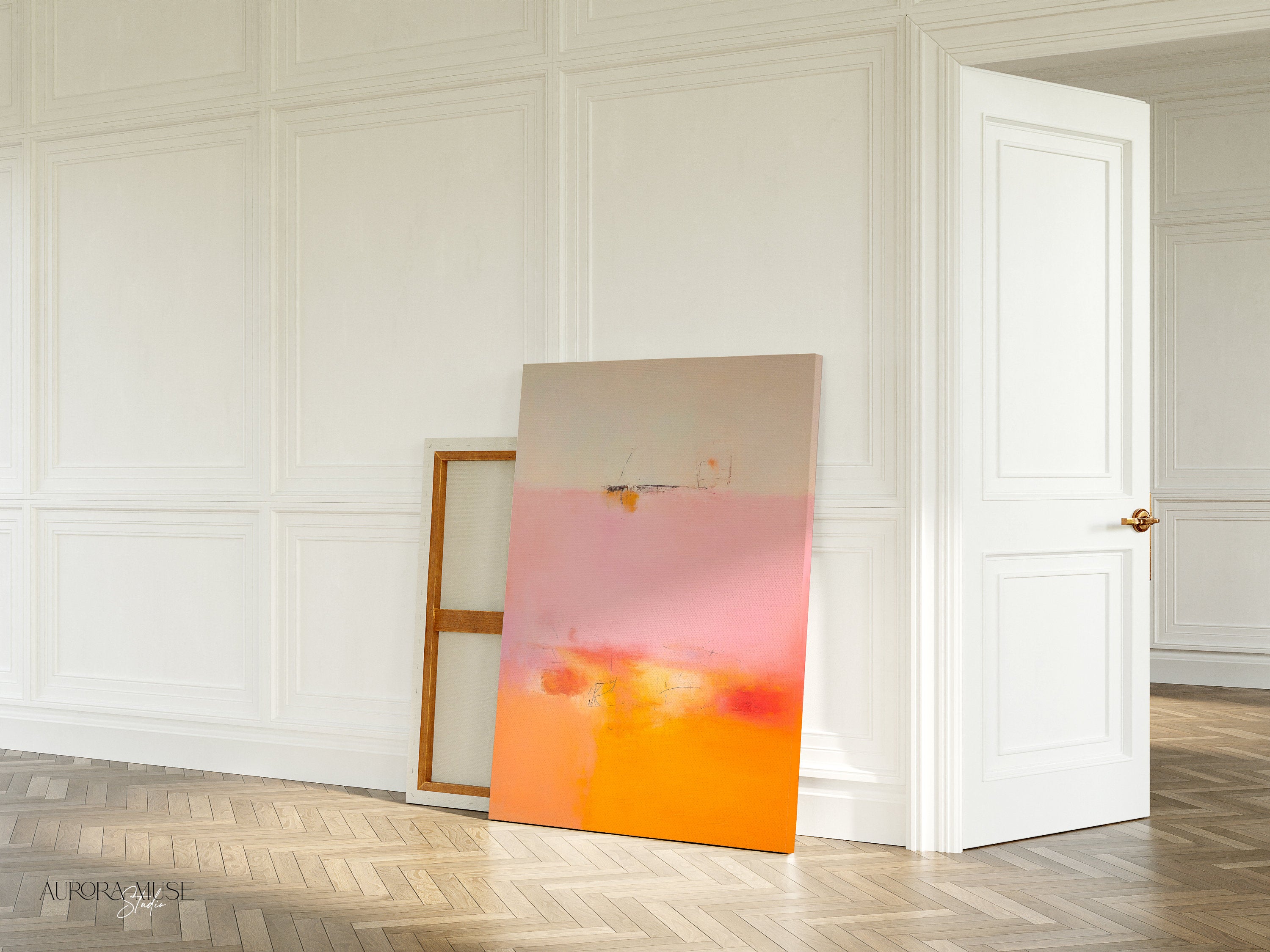 Soft pastel muted abstract wall art featuring a blended pink, peach, and golden gradient, styled in a warm neutral living room with natural wood decor and soft beige seating. Ideal for calm interiors, bedrooms, and warm minimalist spaces. Available as framed wall art, canvas, or fine art print by Muse Studio.