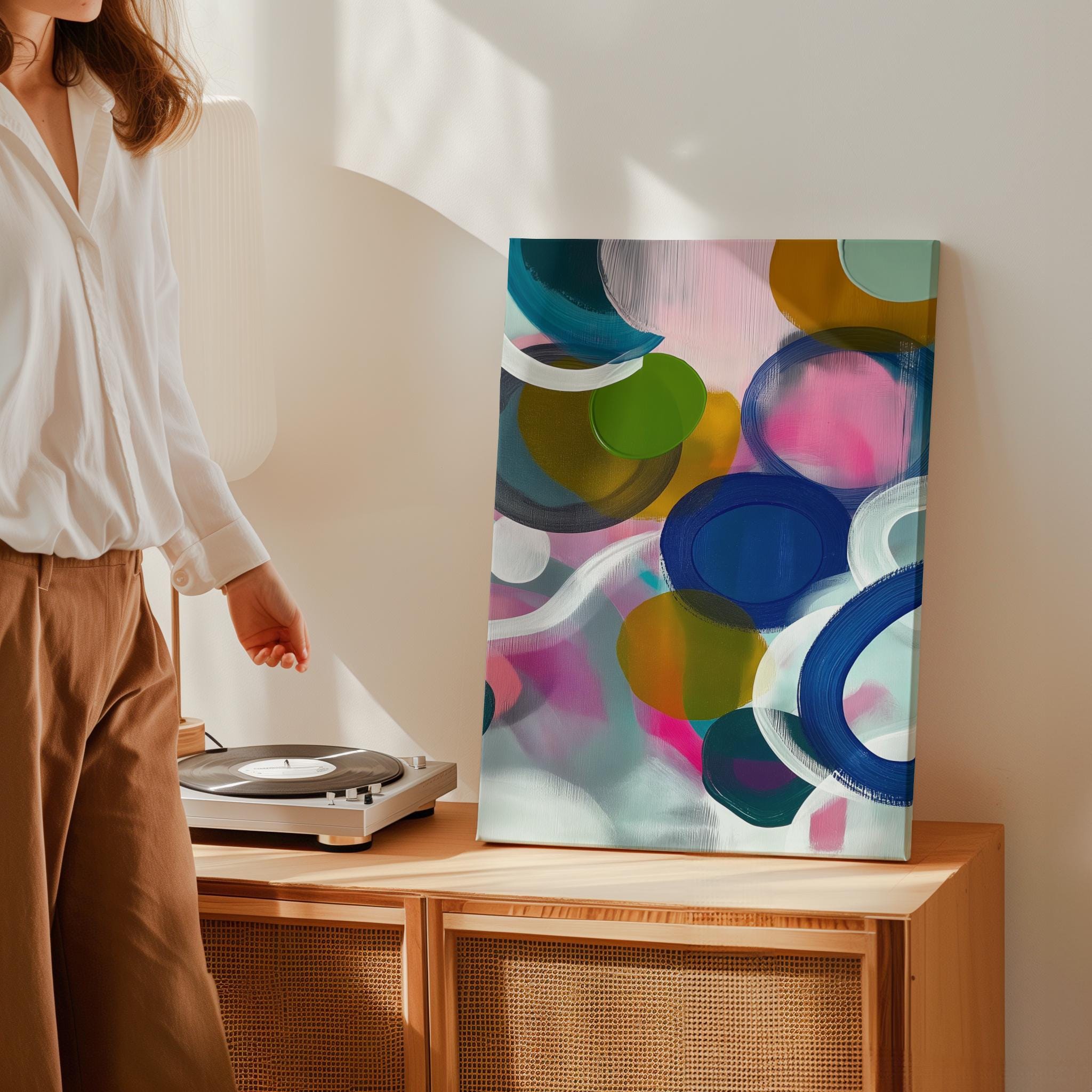Large square abstract wall art featuring bright pink, blue, and green tones in a bold color pop composition, printed as large canvas wall art and styled in a modern living room to create an energetic statement focal point.