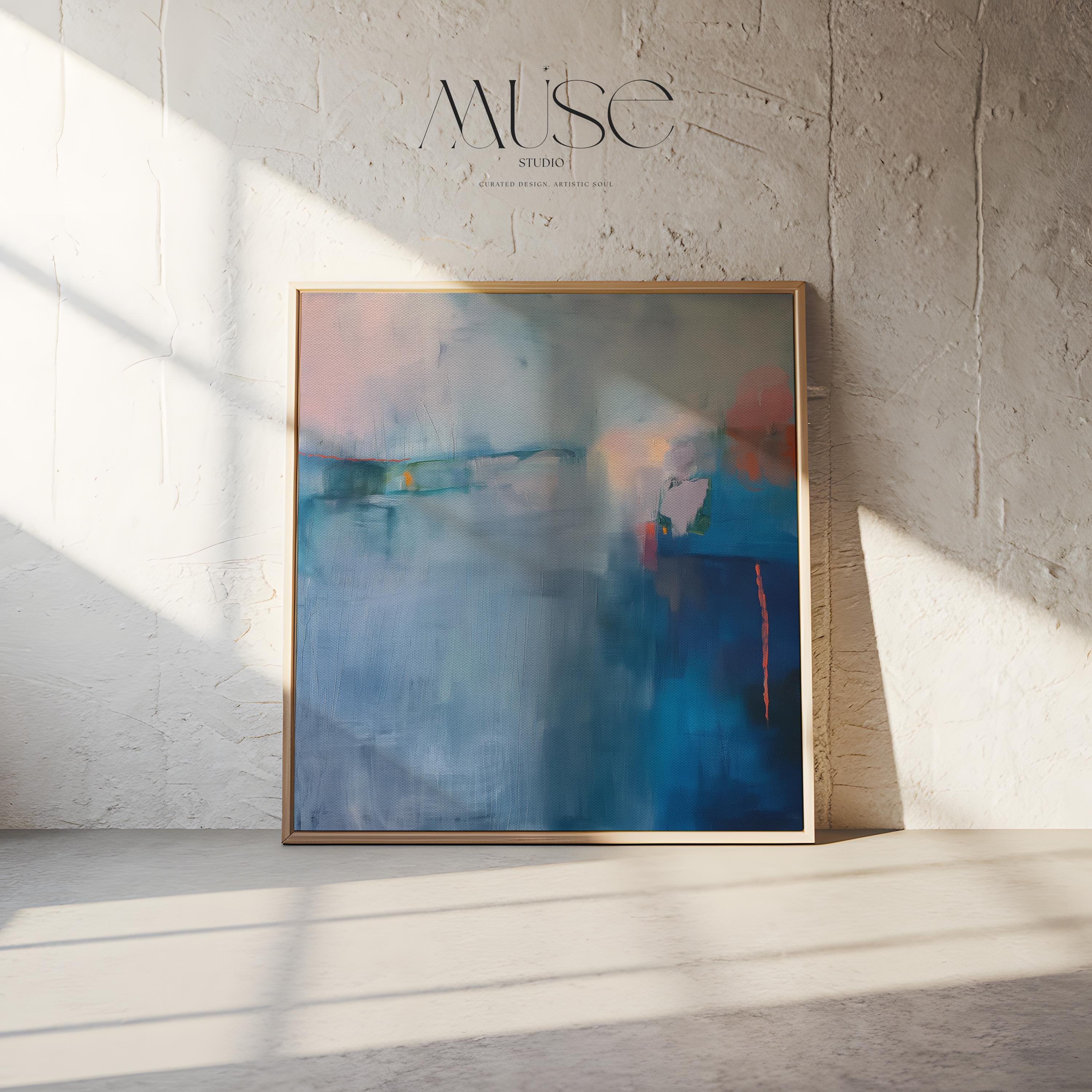 Square framed canvas wall art featuring a moody abstract landscape in rich blue, indigo, blush, and coral tones. This modern piece adds emotional depth and painterly texture to any room. Ideal for coastal interiors, minimalist spaces, or moody decor palettes. Framed in natural wood and displayed on a clean white wall, perfect for offices, living rooms, or curated art walls. Muse Studio original design for refined home styling.