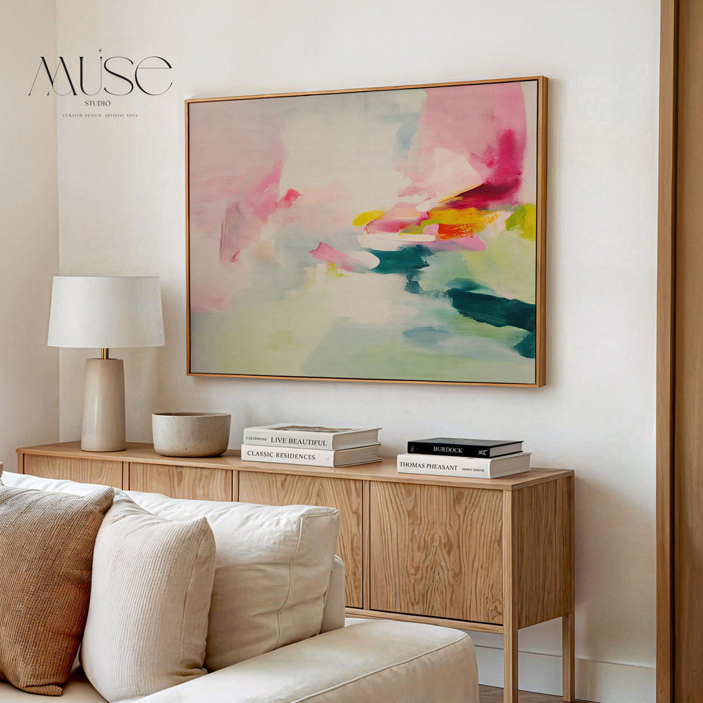 Framed canvas wall art featuring a soft abstract composition in blush pink, teal, lemon yellow, and mint green. The painting blends gentle brushstrokes and airy movement, creating a serene and modern feel. Styled in a sunlit room with warm wood tones, neutral decor, and minimalist furnishings. Perfect for bedrooms, living rooms, or contemporary interiors. Muse Studio artwork designed for curated home decor with a soft contemporary aesthetic.