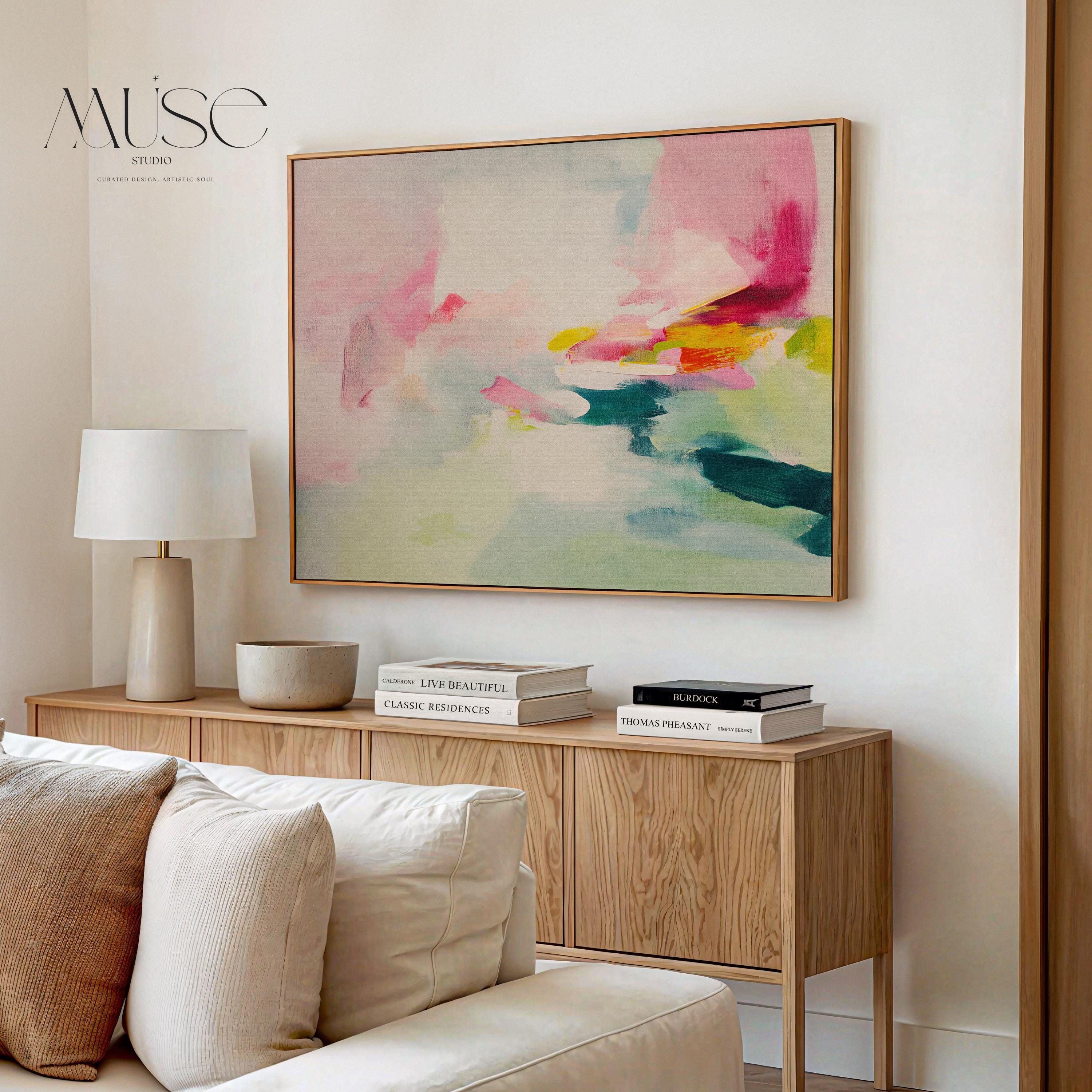 Framed canvas wall art featuring a soft abstract composition in blush pink, teal, lemon yellow, and mint green. The painting blends gentle brushstrokes and airy movement, creating a serene and modern feel. Styled in a sunlit room with warm wood tones, neutral decor, and minimalist furnishings. Perfect for bedrooms, living rooms, or contemporary interiors. Muse Studio artwork designed for curated home decor with a soft contemporary aesthetic.