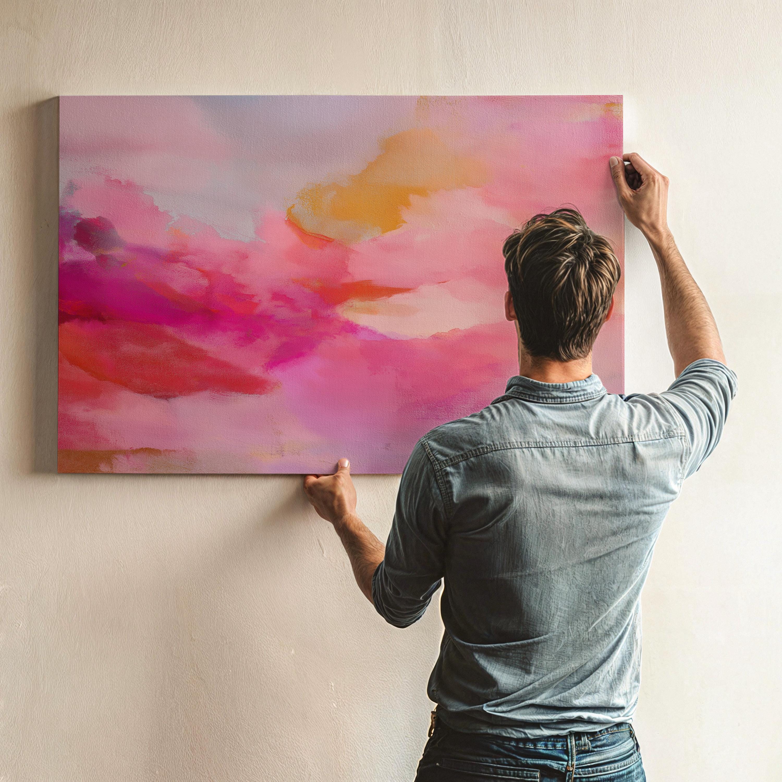Large horizontal stretched canvas wall art in soft pink, golden orange, and warm blush tones. Features an abstract pastel cloudscape with painterly textures. Ideal for dreamy bedrooms, cozy studios, or soft contemporary interiors. Offered as gallery-wrapped canvas or with optional wood floating frame. From the Pink & Blush Wall Art collection by Muse Studio. Available in multiple large-format sizes for statement decor.
