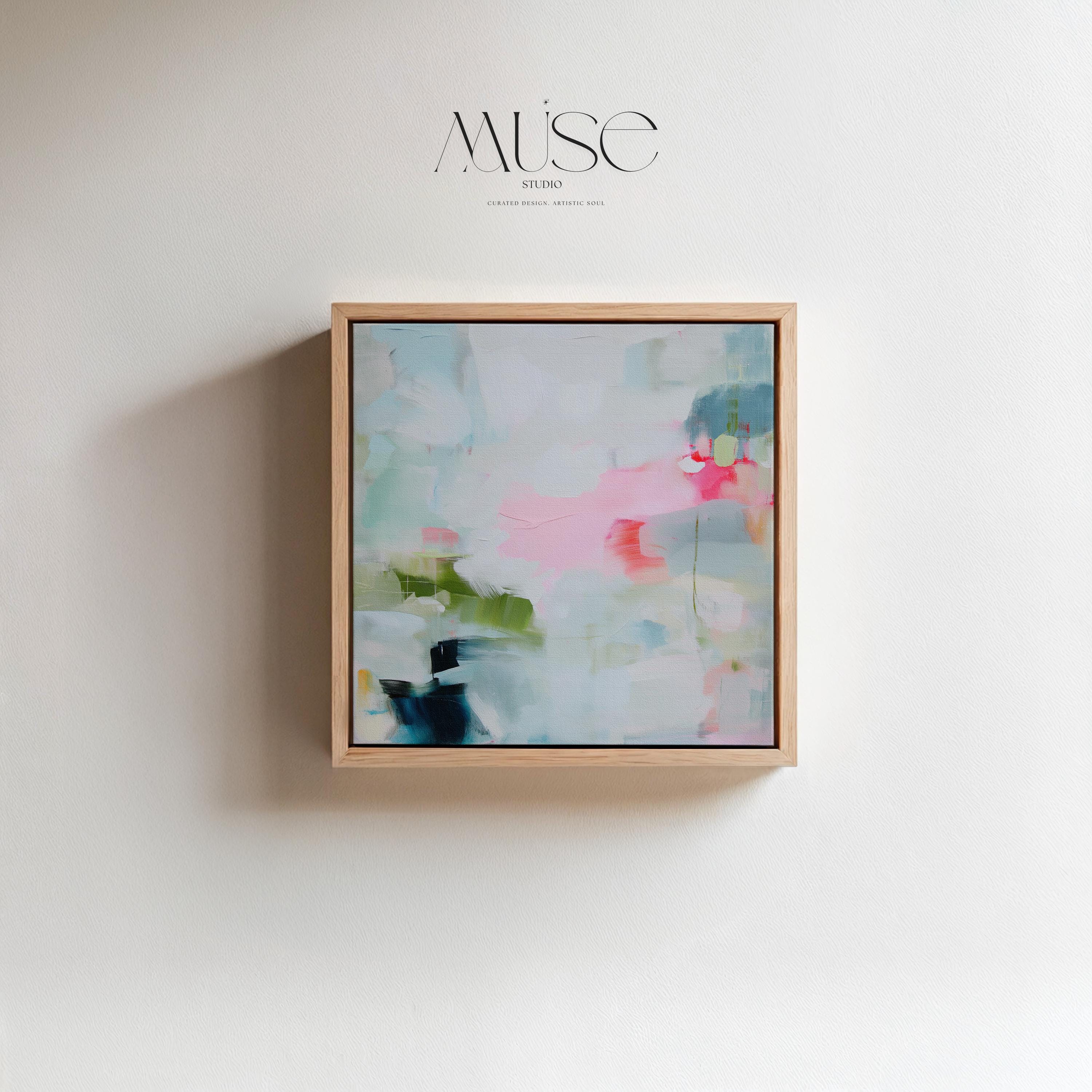 Framed abstract canvas wall art in blush pink, blue, green, and soft neutral tones. Square modern painting with expressive brushstrokes and light color palette. Ideal for bedrooms, home offices, or styled spaces seeking a feminine and fresh decor piece. Presented in a natural wood frame, this soft contemporary artwork adds gentle movement and colorful balance to curated interiors. A Muse Studio original designed for designer-led spaces.