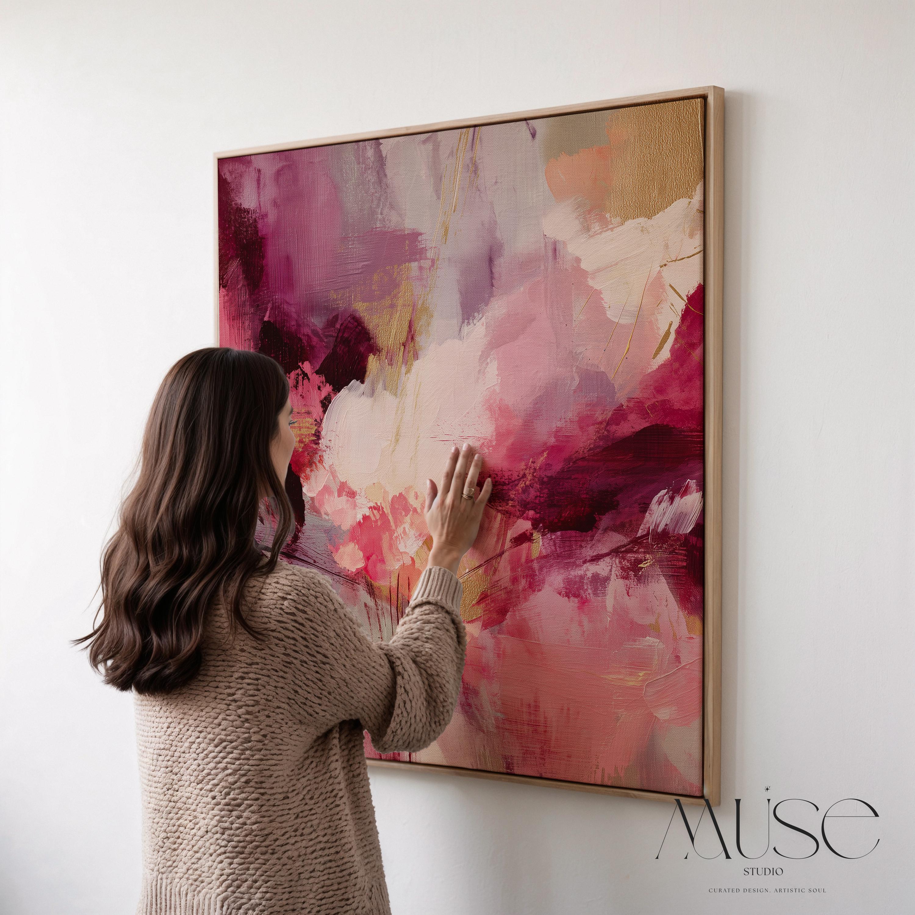 Square abstract wall art featuring expressive layers of raspberry, blush, rose pink, and plum. Aurora 488 by Muse Studio is a bold color pop canvas designed for modern home decor. Shown in natural light with a minimalist setting, this vibrant artwork makes a stunning statement in bedrooms, living rooms, or styled hallways. Offered as a large square framed or unframed canvas, this piece adds drama and artistic elegance to curated spaces.