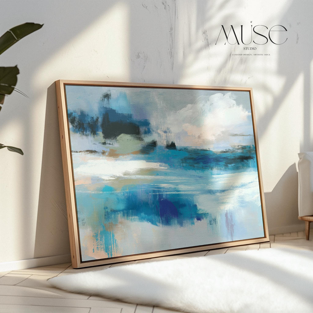Framed horizontal wall art featuring soft painterly layers of ocean blue, sand beige, and sky tones in a modern coastal abstract. Ideal for beach house living rooms, transitional interiors, or above sofa placement. Available as a fine art poster or canvas wall art for curated, color-forward decor.
