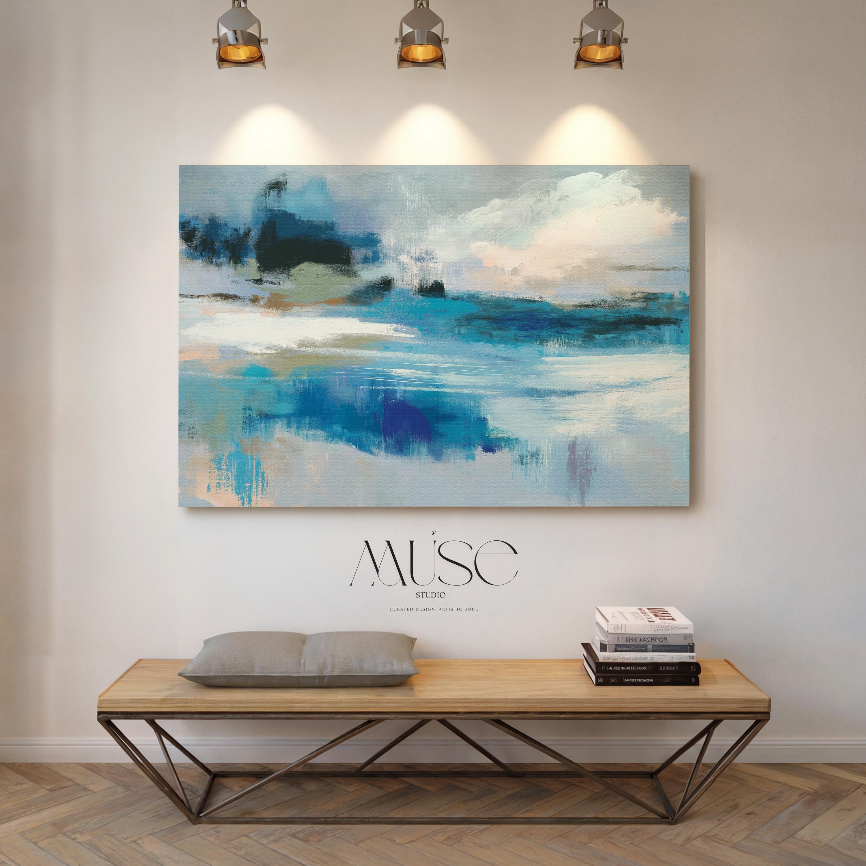 Oversized blue coastal abstract wall art with soft white clouds and ocean-inspired brushstrokes, leaning against paneled walls in a sunlit room. Muted coastal horizon artwork available as framed wall art, canvas, or fine art print by Muse Studio.