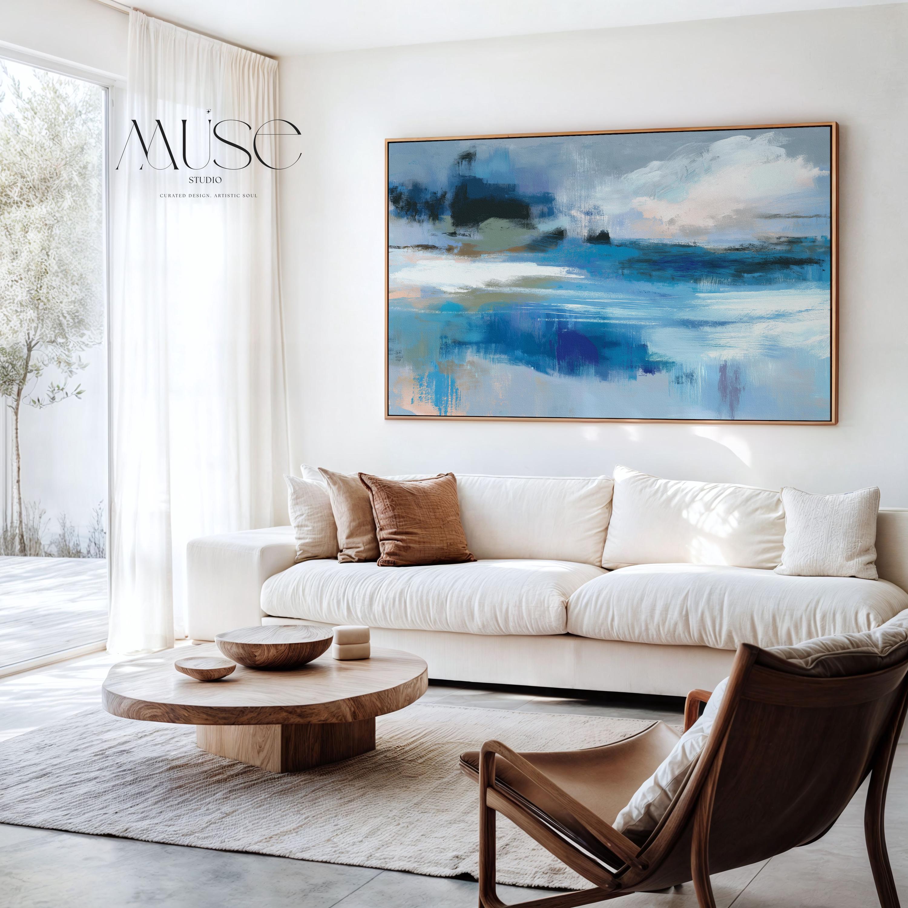 Framed horizontal wall art featuring soft painterly layers of ocean blue, sand beige, and sky tones in a modern coastal abstract. Ideal for beach house living rooms, transitional interiors, or above sofa placement. Available as a fine art poster or canvas wall art for curated, color-forward decor.