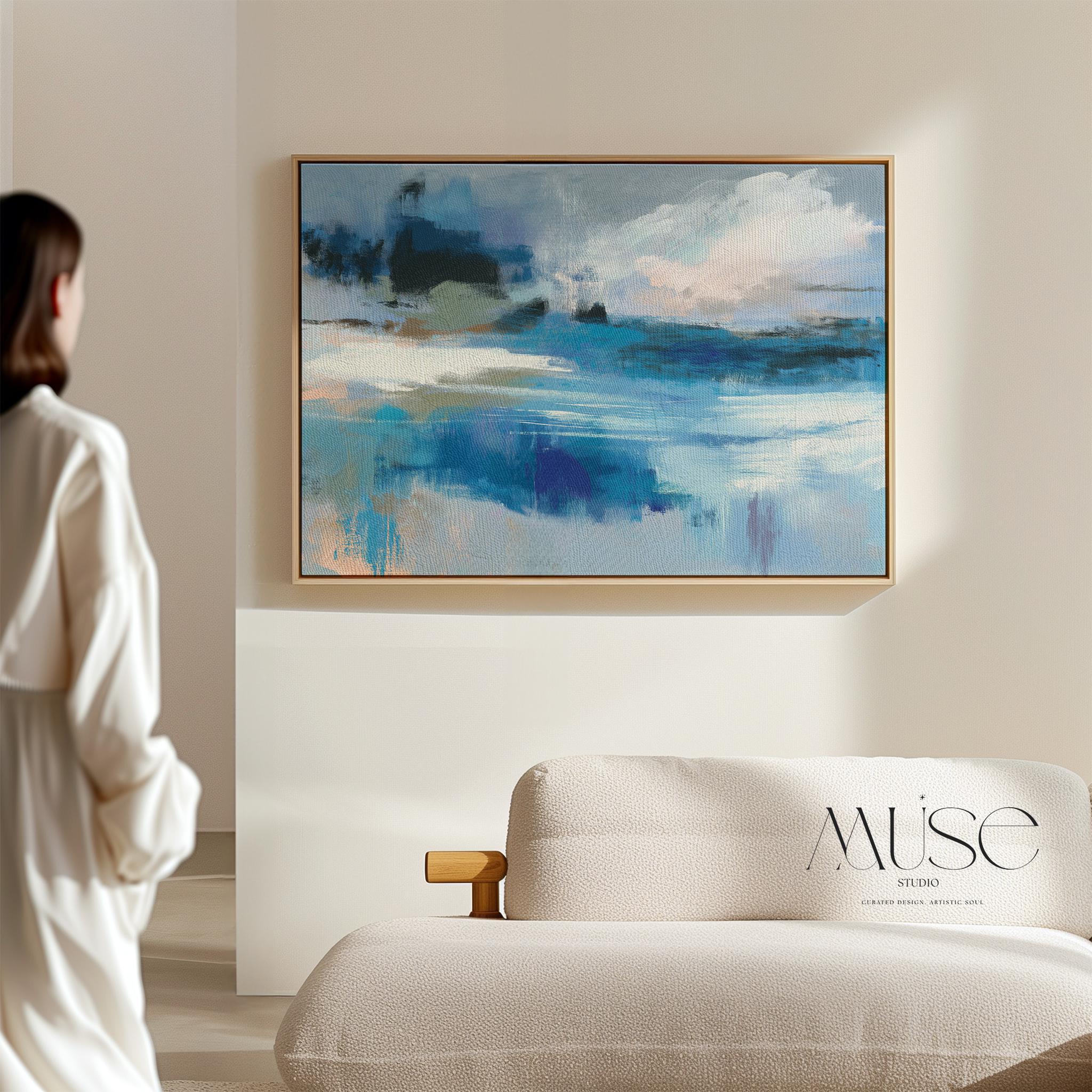 Framed horizontal wall art featuring soft painterly layers of ocean blue, sand beige, and sky tones in a modern coastal abstract. Ideal for beach house living rooms, transitional interiors, or above sofa placement. Available as a fine art poster or canvas wall art for curated, color-forward decor.