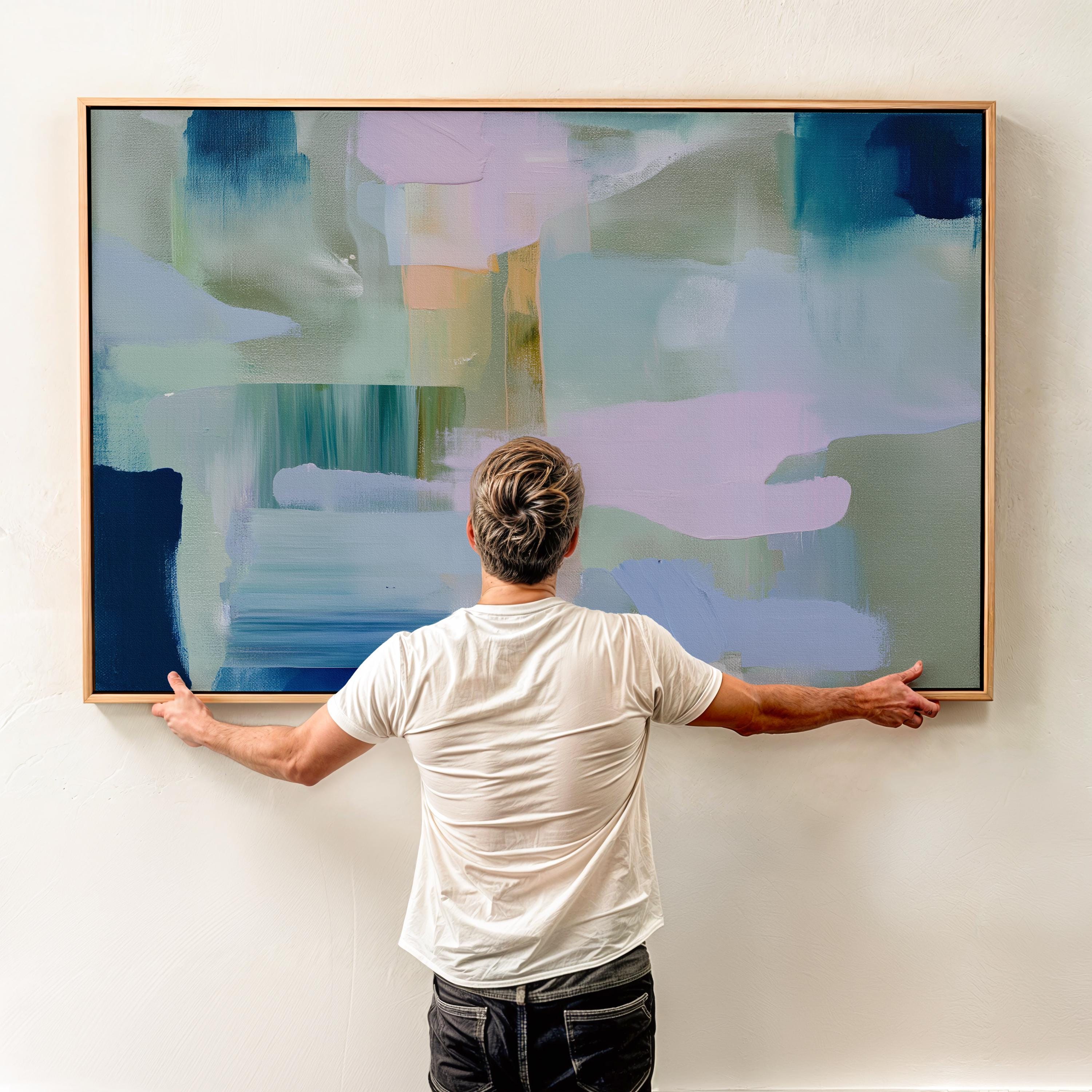 Framed horizontal abstract wall art in coastal blue, sage green, and blush pink, painted with soft layered brushstrokes. A muted modern piece that fits perfectly above sofas, beds, or long entryway walls. Premium floating wood frame for a polished finish. Available as large framed canvas wall art by Muse Studio.