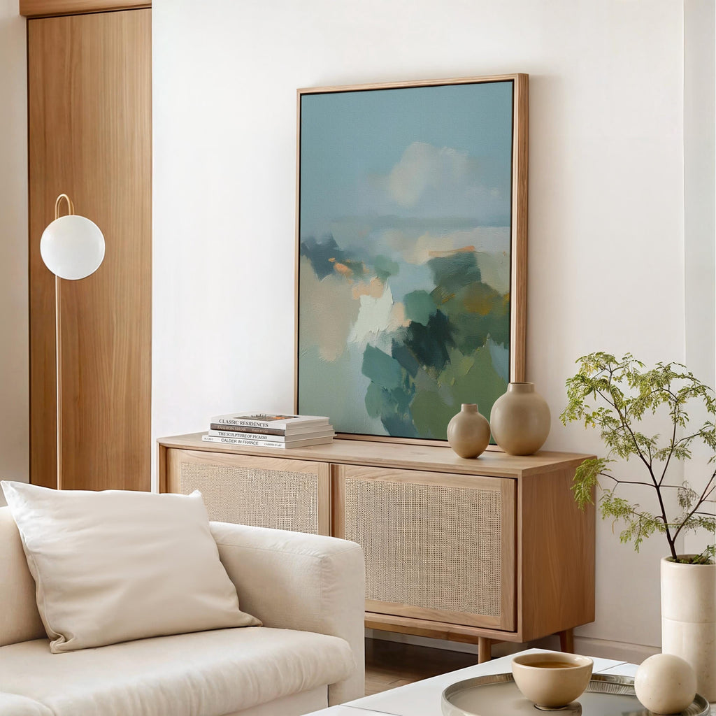 Vertical abstract wall art in teal blue and sage green with soft, misty brushstrokes inspired by nature. Large calming canvas artwork designed for living rooms, bedrooms, and entryways, styled for soft contemporary and coastal interiors. Available as a gallery-wrapped canvas, framed canvas, or fine art print.