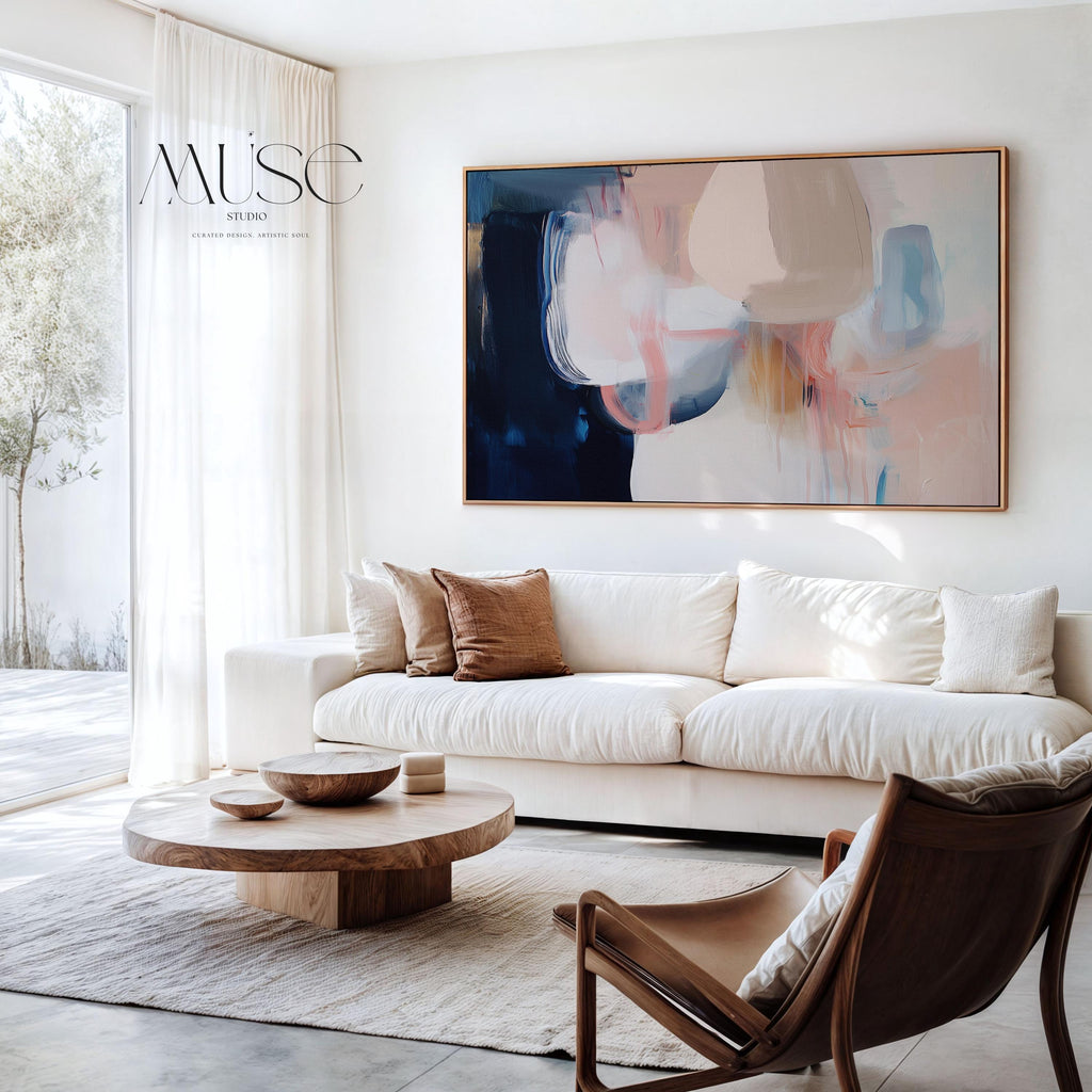 Large framed canvas wall art featuring blush, peach, ivory, muted blue, and navy tones in a horizontal abstract giclée print. Designed in muted neutral style with transitional and soft contemporary appeal, this artwork is perfect for living rooms, dining rooms, or bedrooms. Its calming palette and painterly textures bring balance and elegance to interiors. Available as a floating framed canvas giclée print in multiple large sizes.