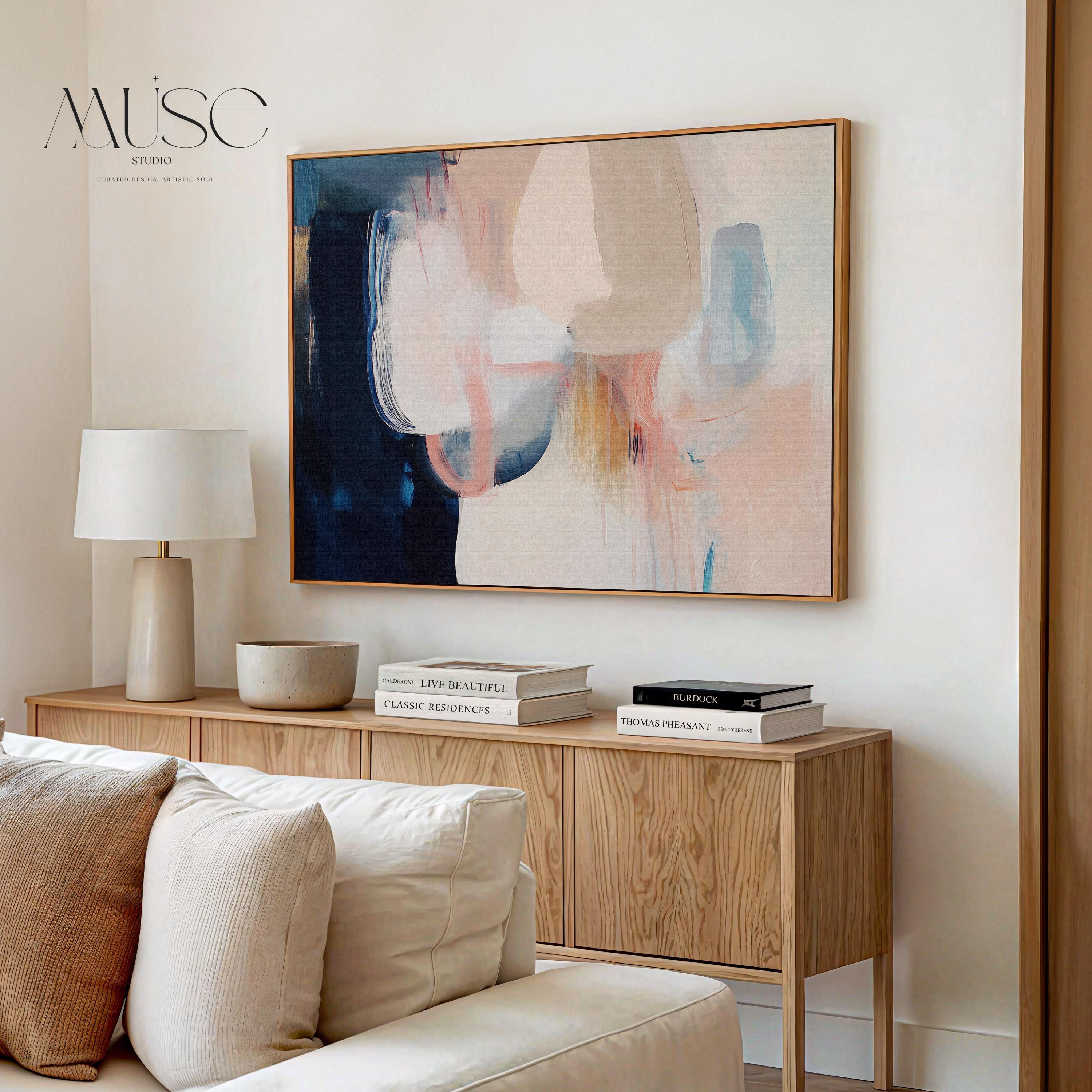 Large framed canvas wall art featuring blush, peach, ivory, muted blue, and navy tones in a horizontal abstract giclée print. Designed in muted neutral style with transitional and soft contemporary appeal, this artwork is perfect for living rooms, dining rooms, or bedrooms. Its calming palette and painterly textures bring balance and elegance to interiors. Available as a floating framed canvas giclée print in multiple large sizes.