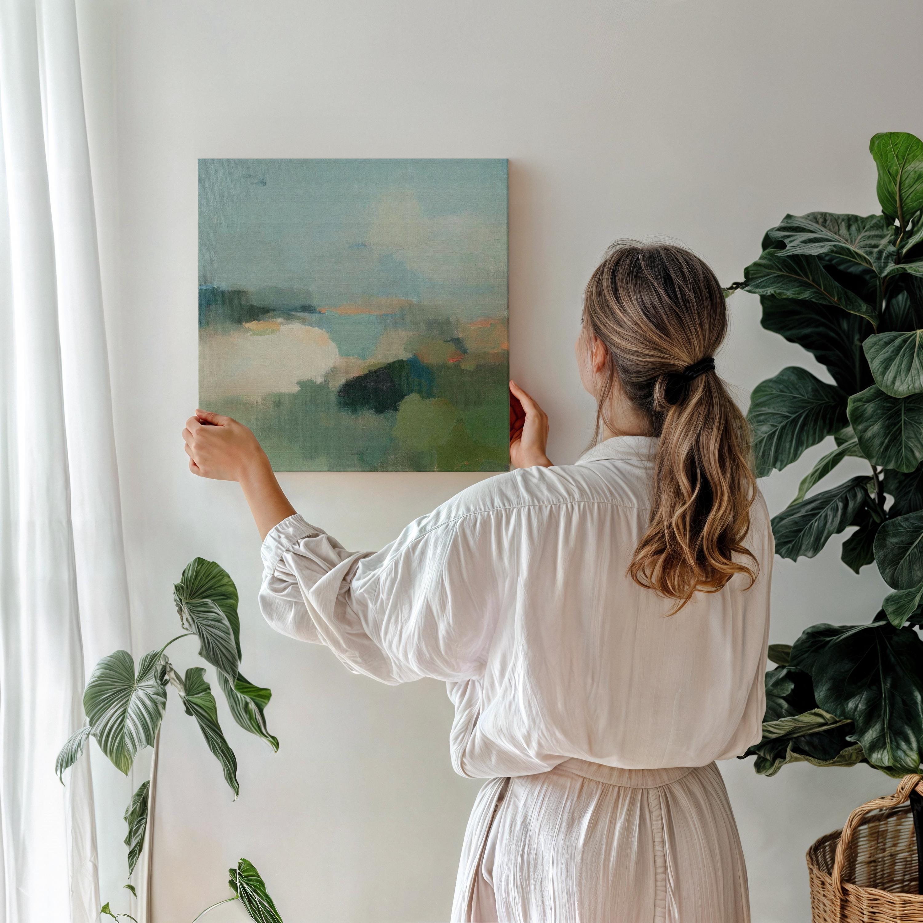 Square abstract wall art in soft greens, muted blues, and earthy tones with a horizon-inspired design. Large canvas artwork styled for modern interiors, perfect for living rooms, bedrooms, or entryways. A calming, nature-inspired piece that complements soft contemporary, coastal, and warm minimalist decor. Available as gallery-wrapped canvas, framed canvas, or fine art print.