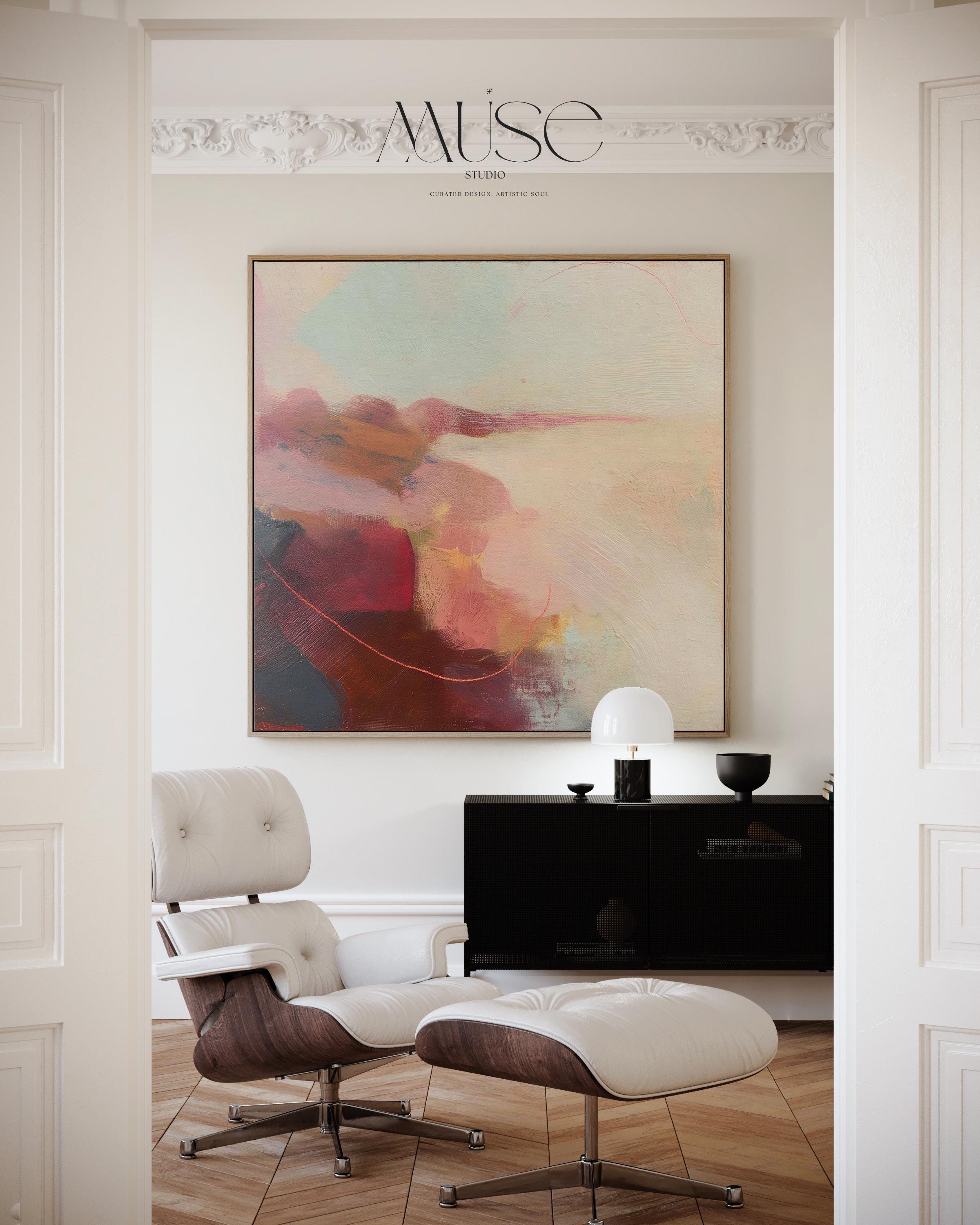 Large square abstract wall art in blush, burgundy, peach, and soft teal tones displayed above a modern black credenza with an Eames lounge chair in a light, elegant room. Warm contemporary abstract canvas for living room or designer interiors, available as framed wall art or canvas by Muse Studio.