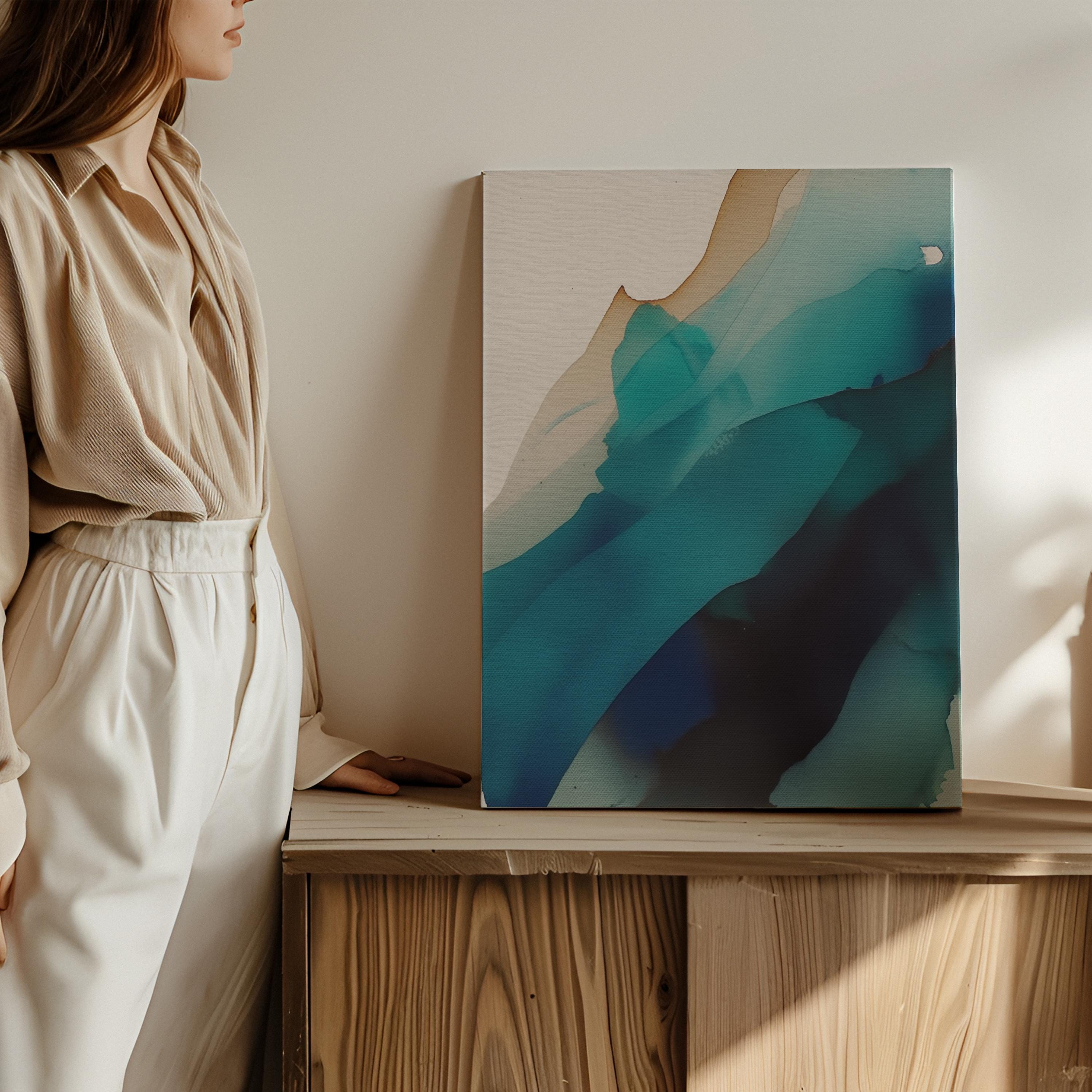 Vertical canvas wall art featuring deep teal, navy, aqua, and soft sand tones in a fluid, ink-wash abstract style. This nature-inspired design blends organic motion with a tranquil, modern aesthetic—perfect for soft contemporary interiors, stairwells, or coastal-inspired living rooms. Available as a gallery-wrapped or floating frame canvas from Muse Studio for designer-level wall styling.