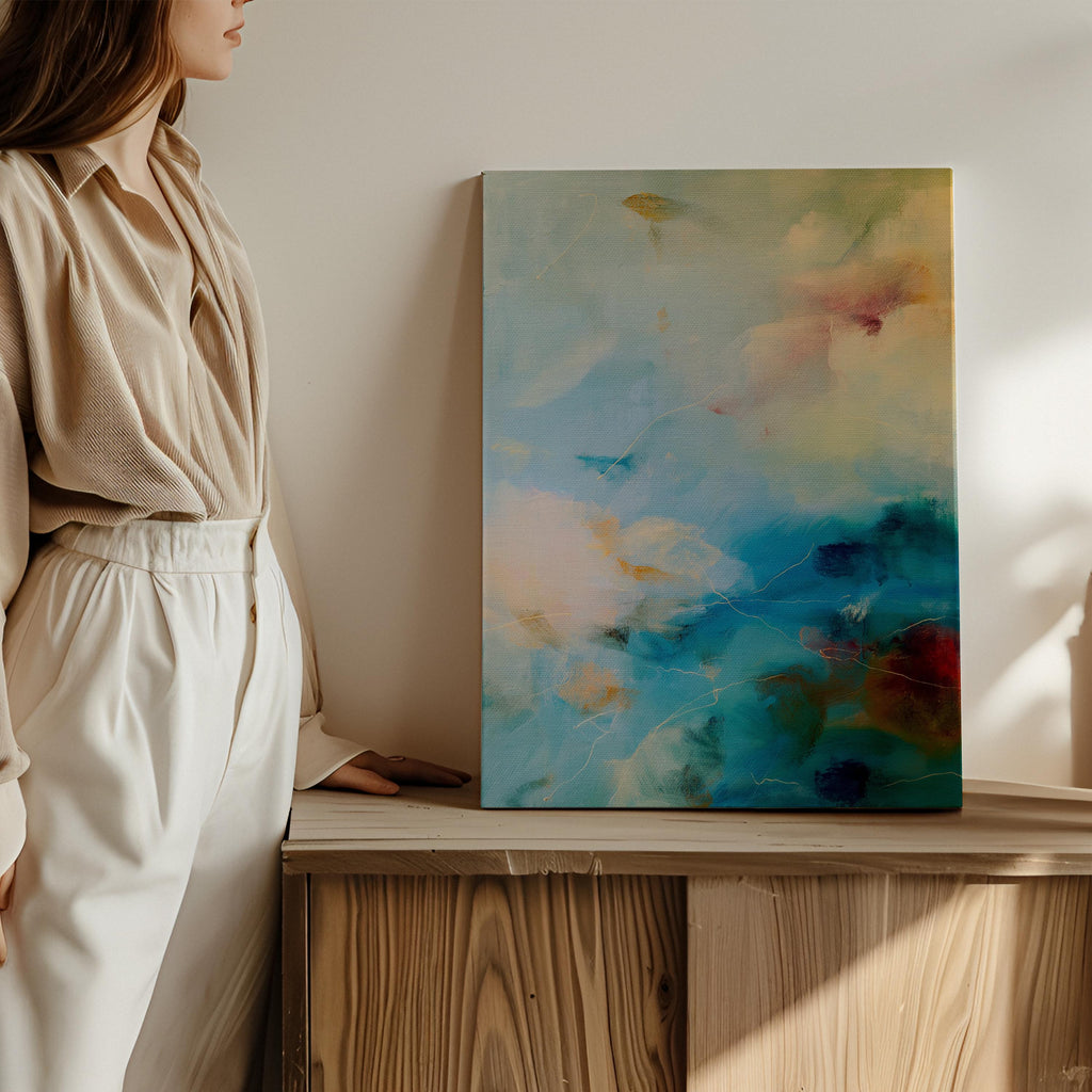Vertical canvas wall art featuring an abstract design in teal blue, pale cream, soft blush, and warm ochre with hints of plum. This tranquil composition evokes the soothing energy of coastal skies and ocean mist. Perfect for a spa bathroom, entryway, or serene retreat. Complements nature-inspired, warm minimalist, or coastal interiors. Available as a gallery-wrapped stretched canvas, framed canvas, or fine art poster print. Original artwork by Muse Studio.