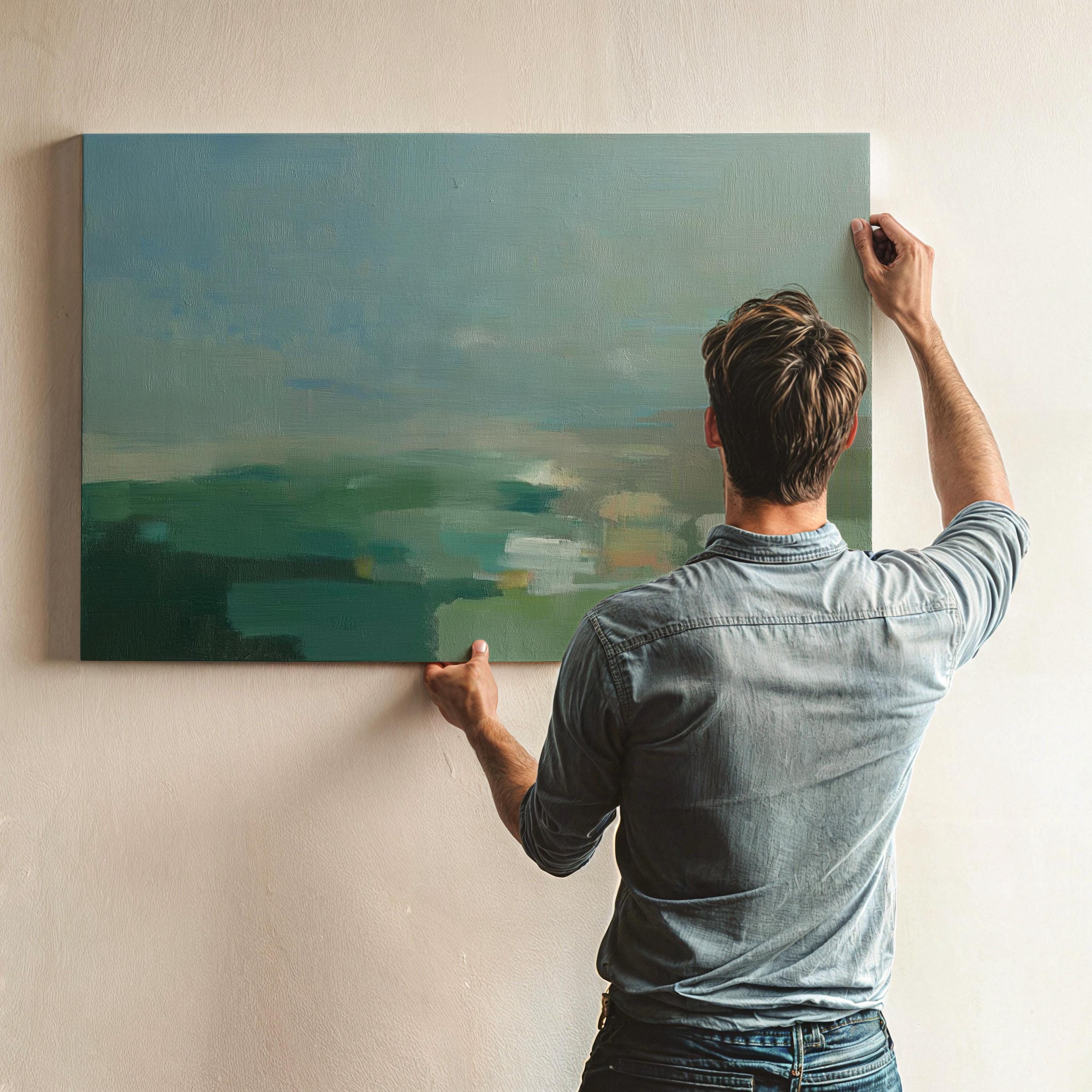 Horizontal abstract wall art in sage green, teal, and muted earth tones with soft blended brushstrokes that resemble a peaceful horizon. Large calming artwork designed for minimalist, nature-inspired, and coastal interiors. Perfect for living rooms, bedrooms, or entryways seeking serene modern decor. Available as gallery-wrapped canvas, framed canvas, or fine art print for versatile styling.