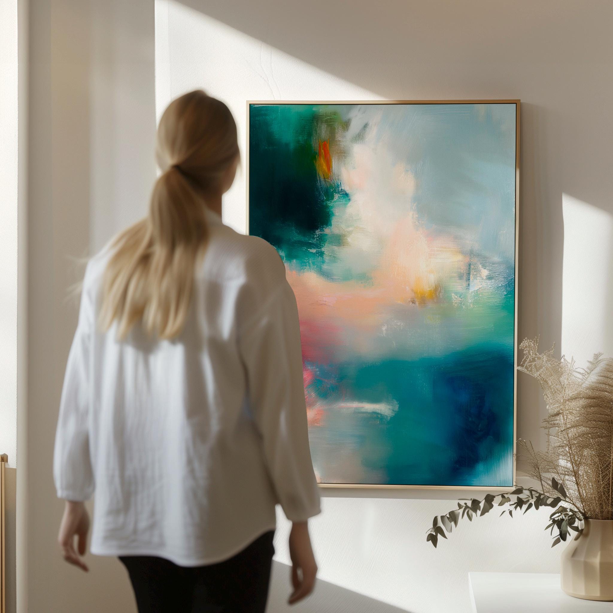 Vertical abstract canvas wall art featuring teal, blush, and gold tones with layered brushwork. The soft contemporary palette enhances modern and transitional interiors, ideal for bedrooms or living spaces. Available as a framed or gallery-wrapped canvas for designer-inspired decor.