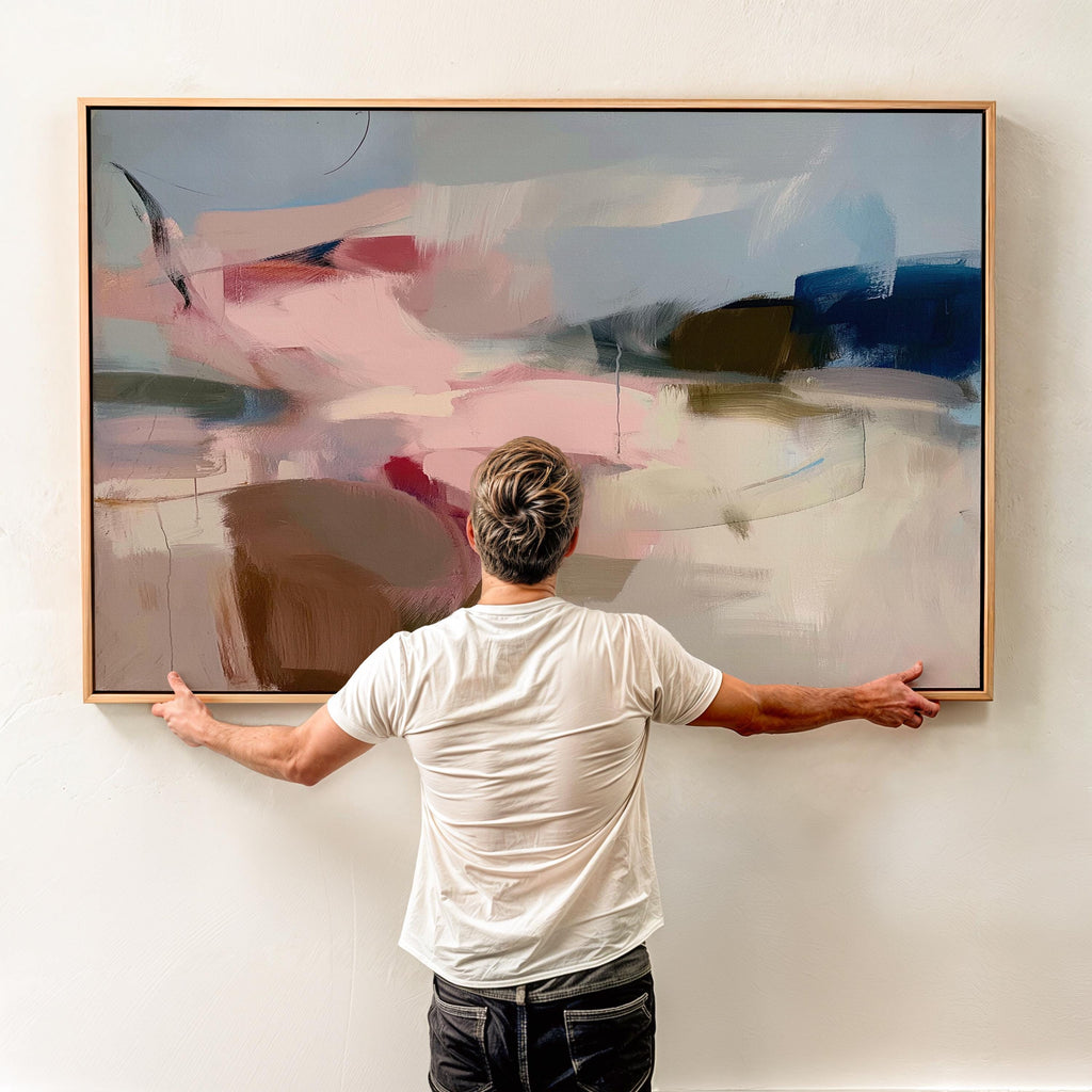 Horizontal abstract canvas wall art in soft blush, navy, and taupe tones with gentle painterly movement. The textured brushwork evokes warmth and calm, ideal for modern living rooms or bedrooms. Printed on premium cotton canvas, this gallery-wrapped piece arrives ready to hang for a clean, contemporary finish.