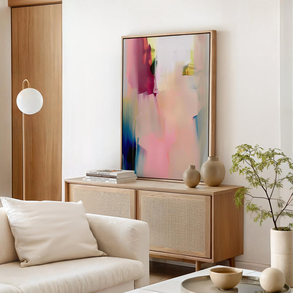 Vertical framed canvas wall art in soft blush rose, ivory, and coral tones, layered with hints of cobalt and gold. Gentle painterly motion evokes calm elegance, ideal for Soft Contemporary and Warm Neutral interiors. Perfect for living rooms or entryways. Handcrafted fine art giclée on cotton canvas.