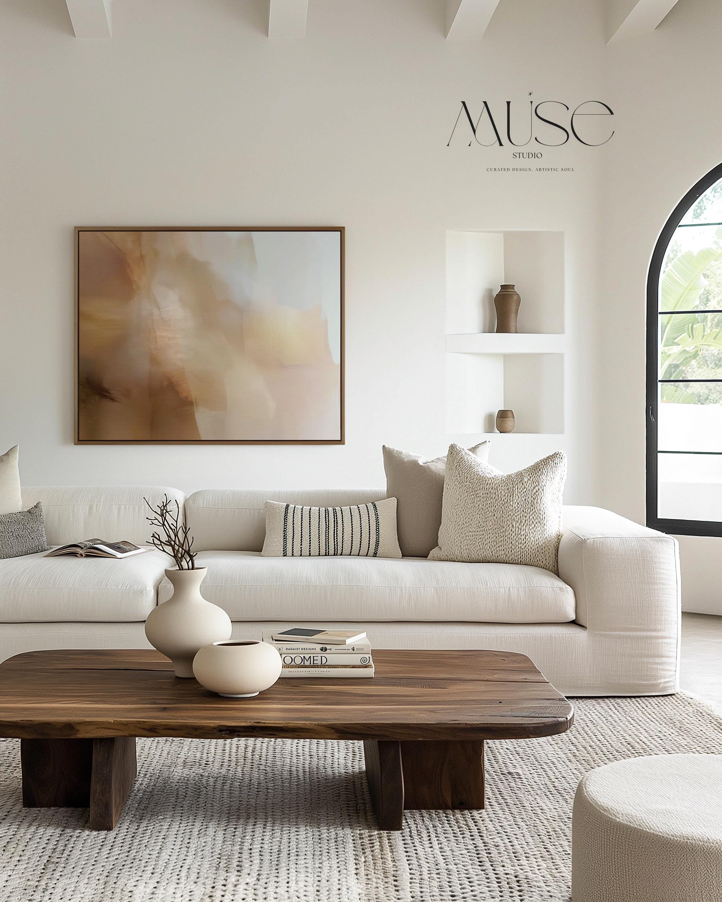 Horizontal warm-neutral abstract wall art in beige, sand, and ivory tones, styled in a warm minimal interior with light wood and linen textures. Available as framed canvas or gallery canvas by Muse Studio.