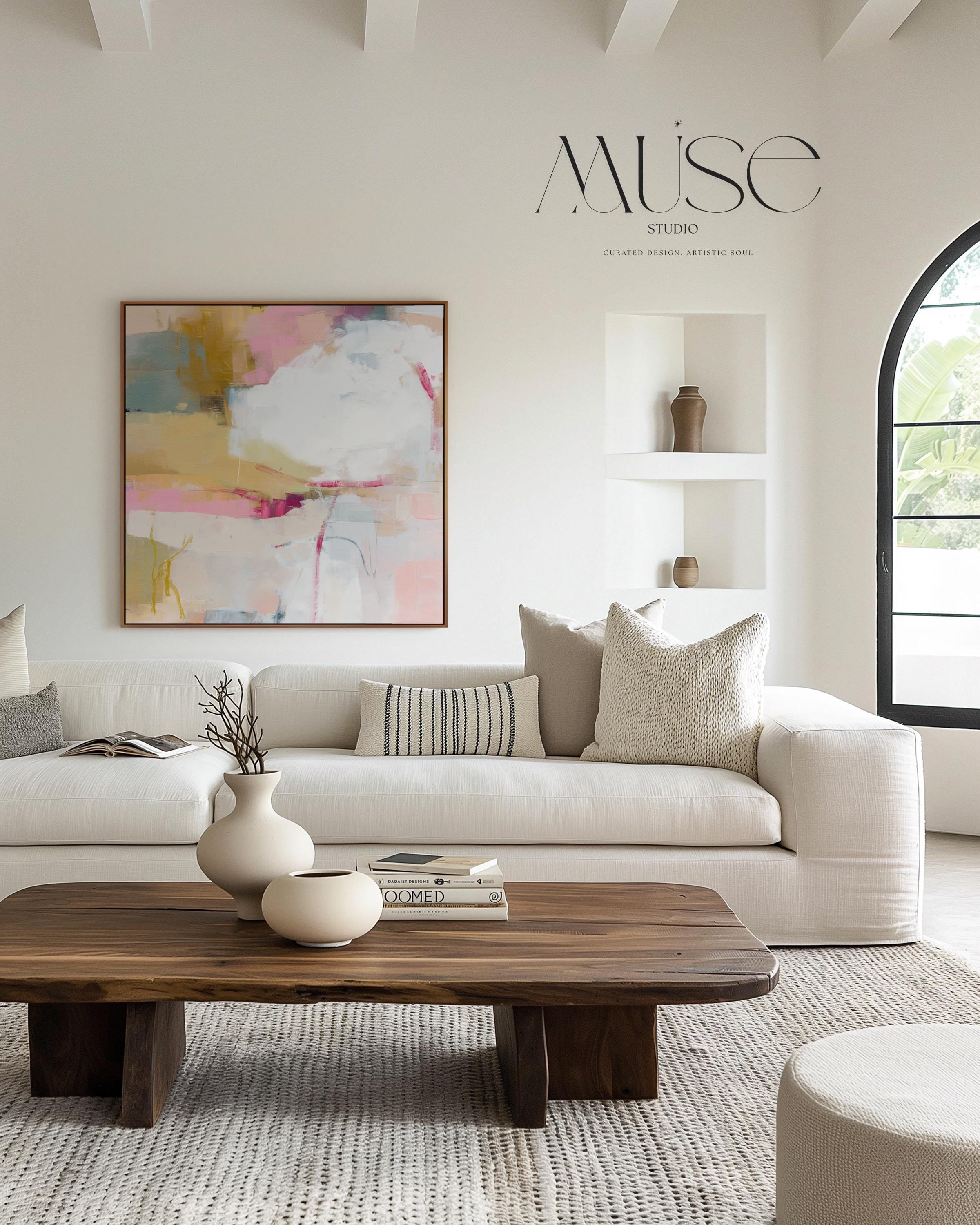 Square abstract wall art in soft pink, mustard, white, and teal tones framed in natural wood and displayed on a clean white wall. Light pastel contemporary artwork with gentle brushwork, ideal for modern living rooms, bedrooms, or designer interiors. Available as framed canvas or giclée print by Muse Studio.