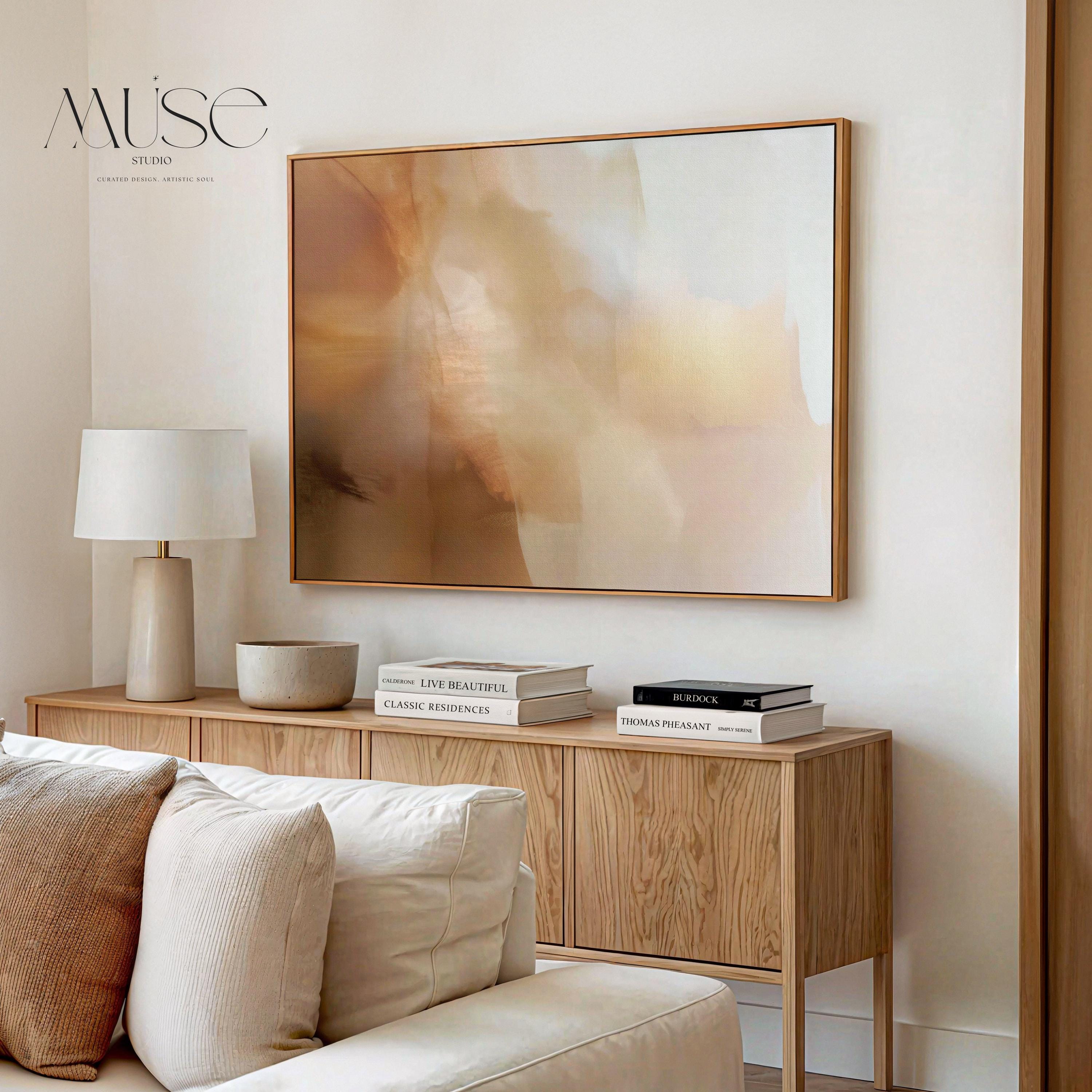 Horizontal warm-neutral abstract wall art in beige, sand, and ivory tones, styled in a warm minimal interior with light wood and linen textures. Available as framed canvas or gallery canvas by Muse Studio.