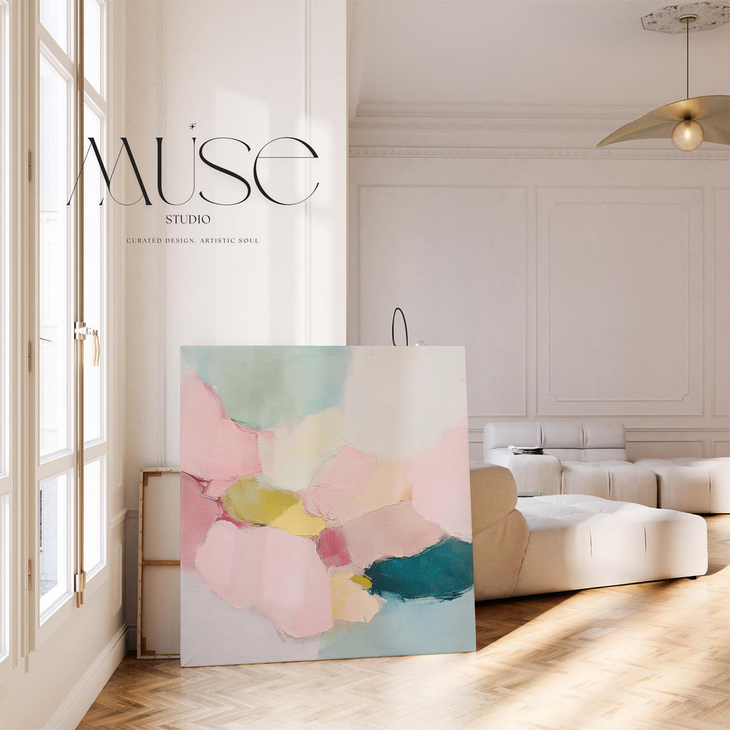 Large square abstract canvas wall art featuring blush pink, muted teal, pale aqua blue, and butter yellow painterly shapes with visible texture, styled above a modern sofa in a calm contemporary living room, offering soft color contrast and quiet luxury in oversized square format.