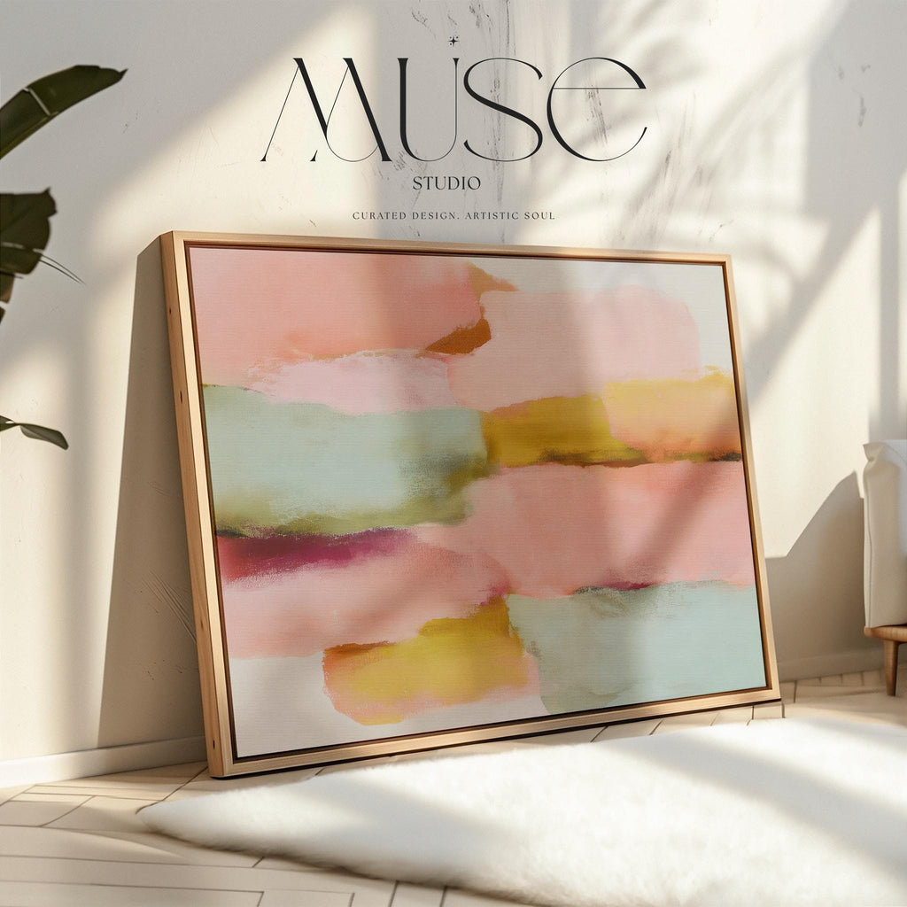 Large horizontal abstract framed canvas wall art featuring blush pink, coral, muted aqua blue, golden ochre, and plum layered brushstrokes, styled above a neutral sofa in a modern living room, offering warm contemporary color and balanced movement for oversized wall placement.