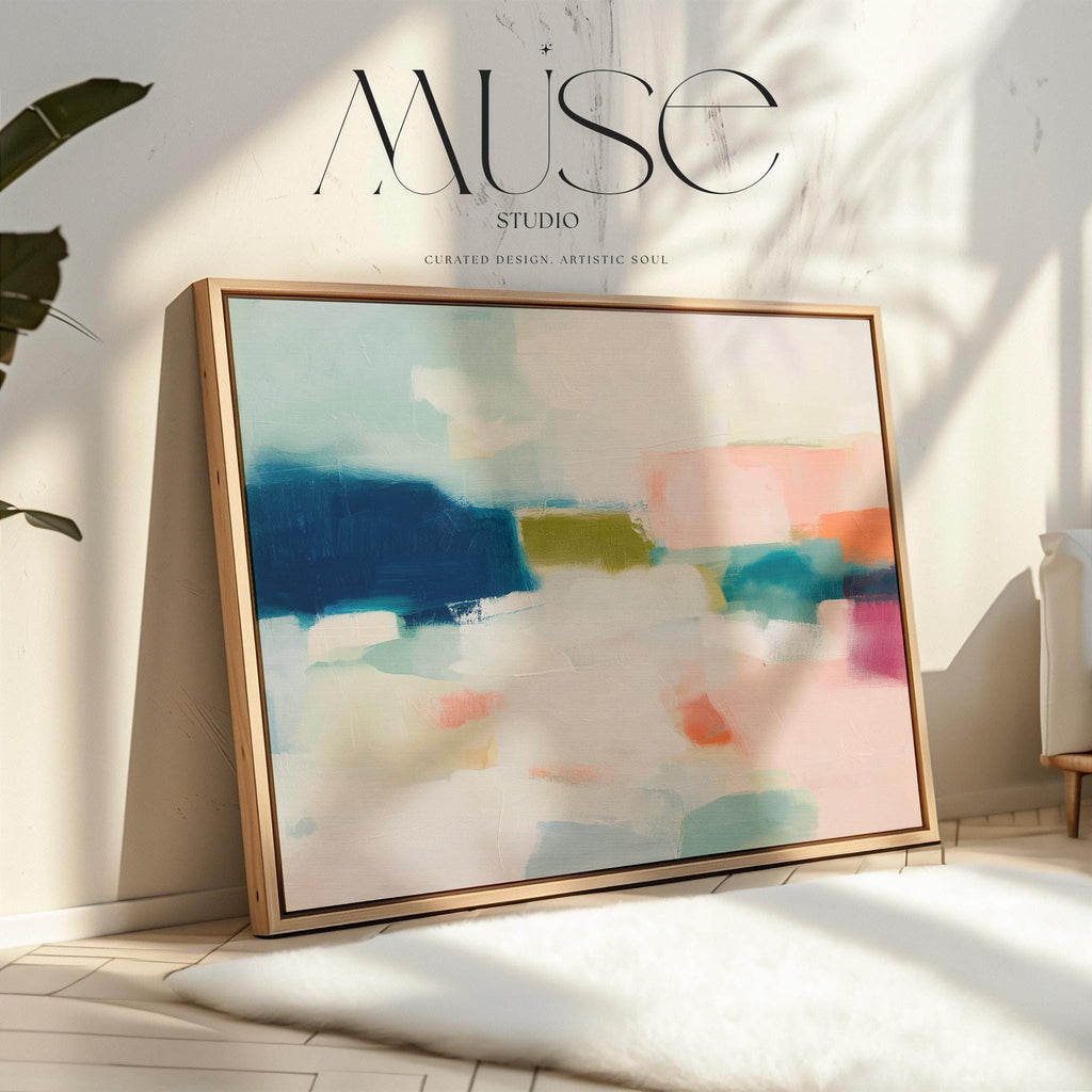 Large horizontal abstract framed canvas wall art featuring deep navy blue, muted aqua, soft blush pink, olive green, coral accents, and layered white brushstrokes, styled above a neutral sofa in a modern coastal living room, offering balanced contrast and refined contemporary color.