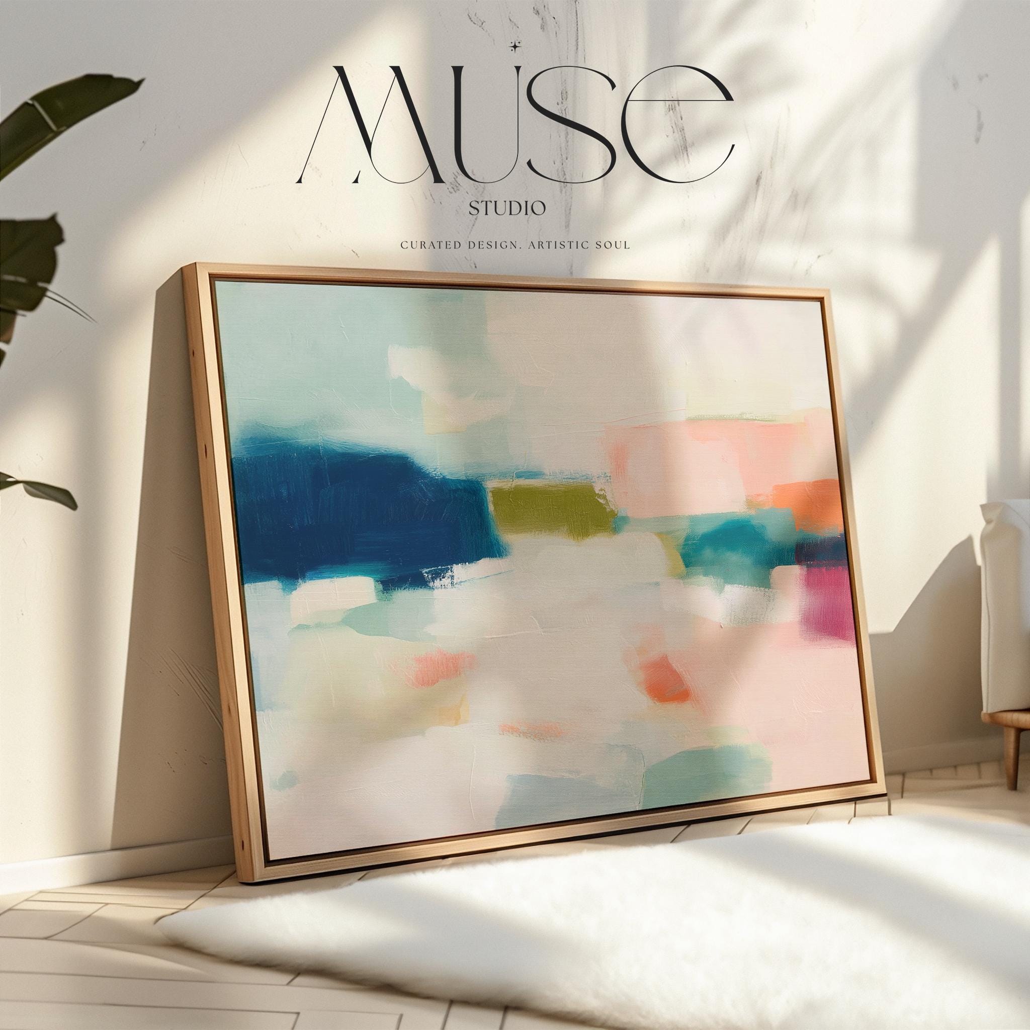 Large horizontal abstract framed canvas wall art featuring deep navy blue, muted aqua, soft blush pink, olive green, coral accents, and layered white brushstrokes, styled above a neutral sofa in a modern coastal living room, offering balanced contrast and refined contemporary color.