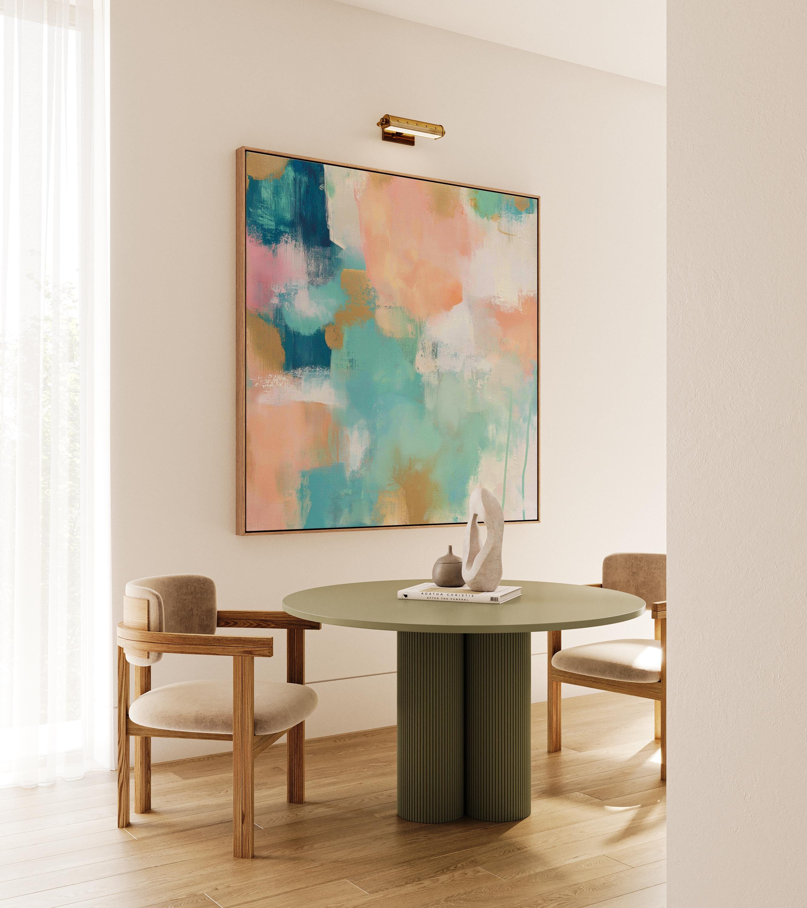 Large square abstract framed canvas wall art featuring coral, peach, teal, aqua blue, and warm sand tones layered over a soft cream background, styled above a neutral sofa, adding soft color contrast and airy painterly texture to a curated living space.