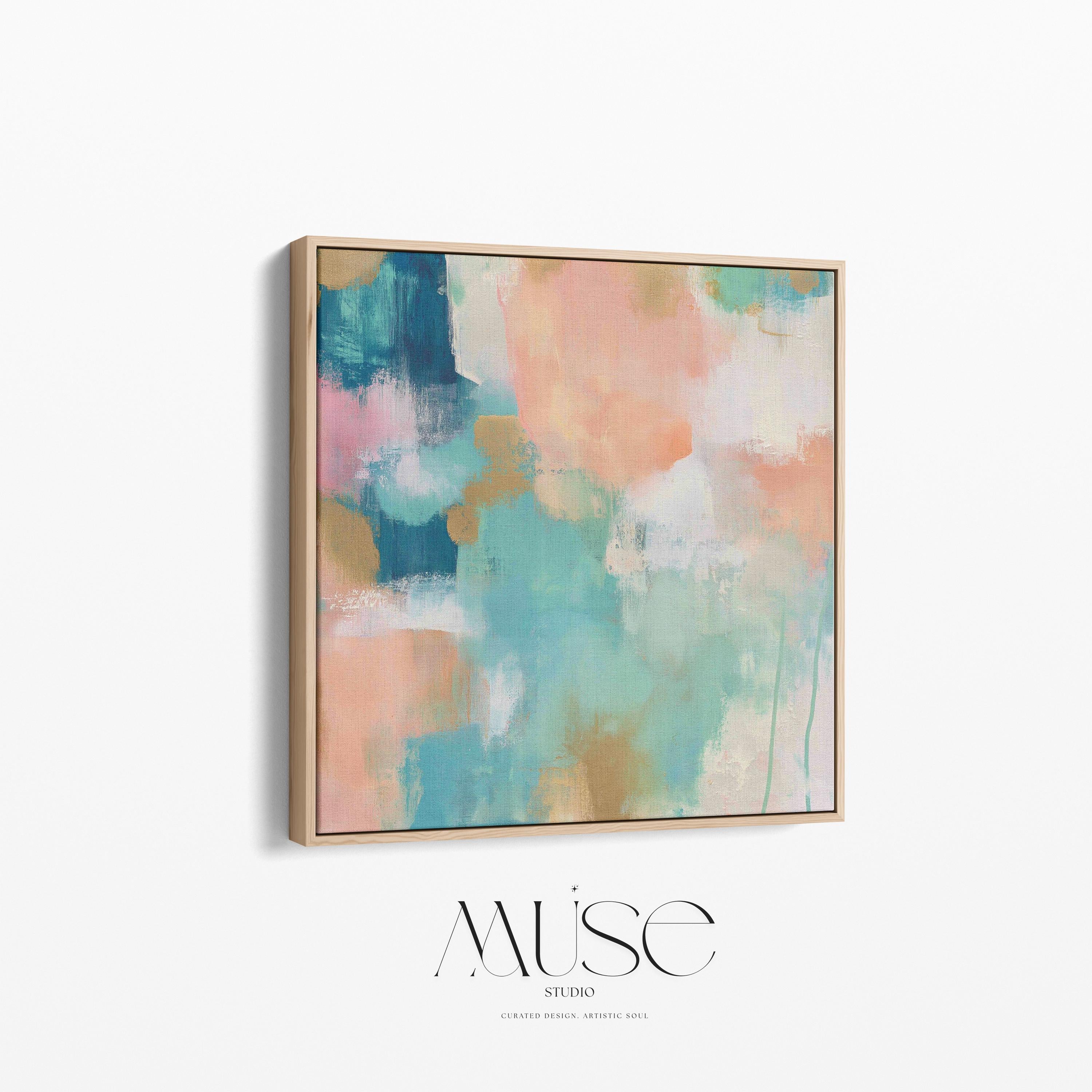 Large square abstract framed canvas wall art featuring coral, peach, teal, aqua blue, and warm sand tones layered over a soft cream background, styled above a neutral sofa, adding soft color contrast and airy painterly texture to a curated living space.