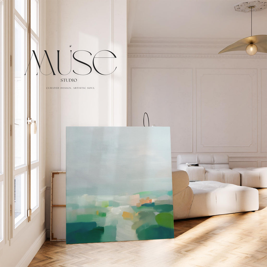 Large square abstract canvas wall art featuring soft green, aqua, and muted blue tones in a calming landscape composition, styled in a neutral interior to create an airy, refined focal point for living rooms or bedrooms.