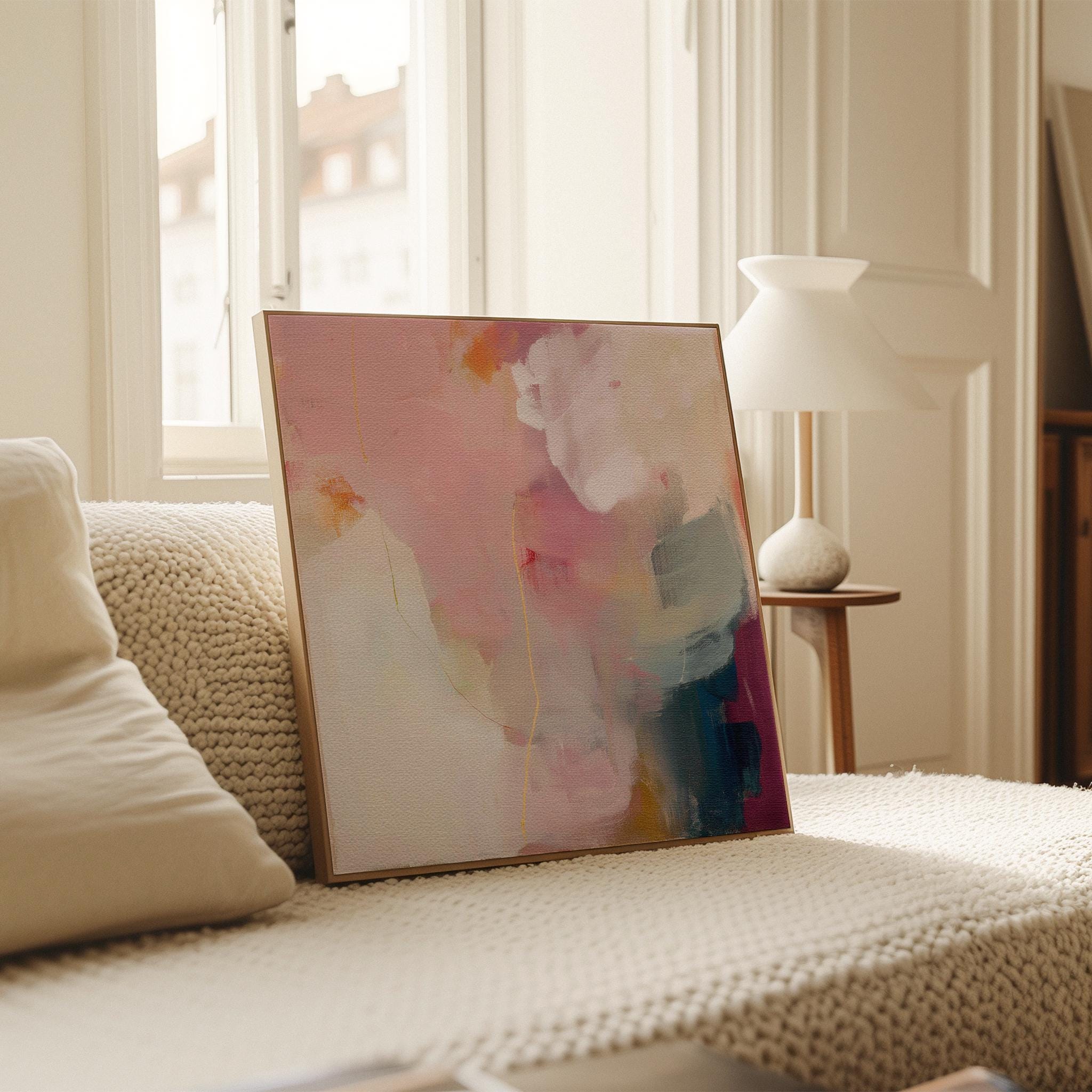 Large square abstract wall art in blush pink, warm cream, muted coral, and deep plum tones, printed as gallery-wrapped large canvas wall art, styled above a neutral sofa to create a romantic, painterly focal point for living rooms or bedrooms.