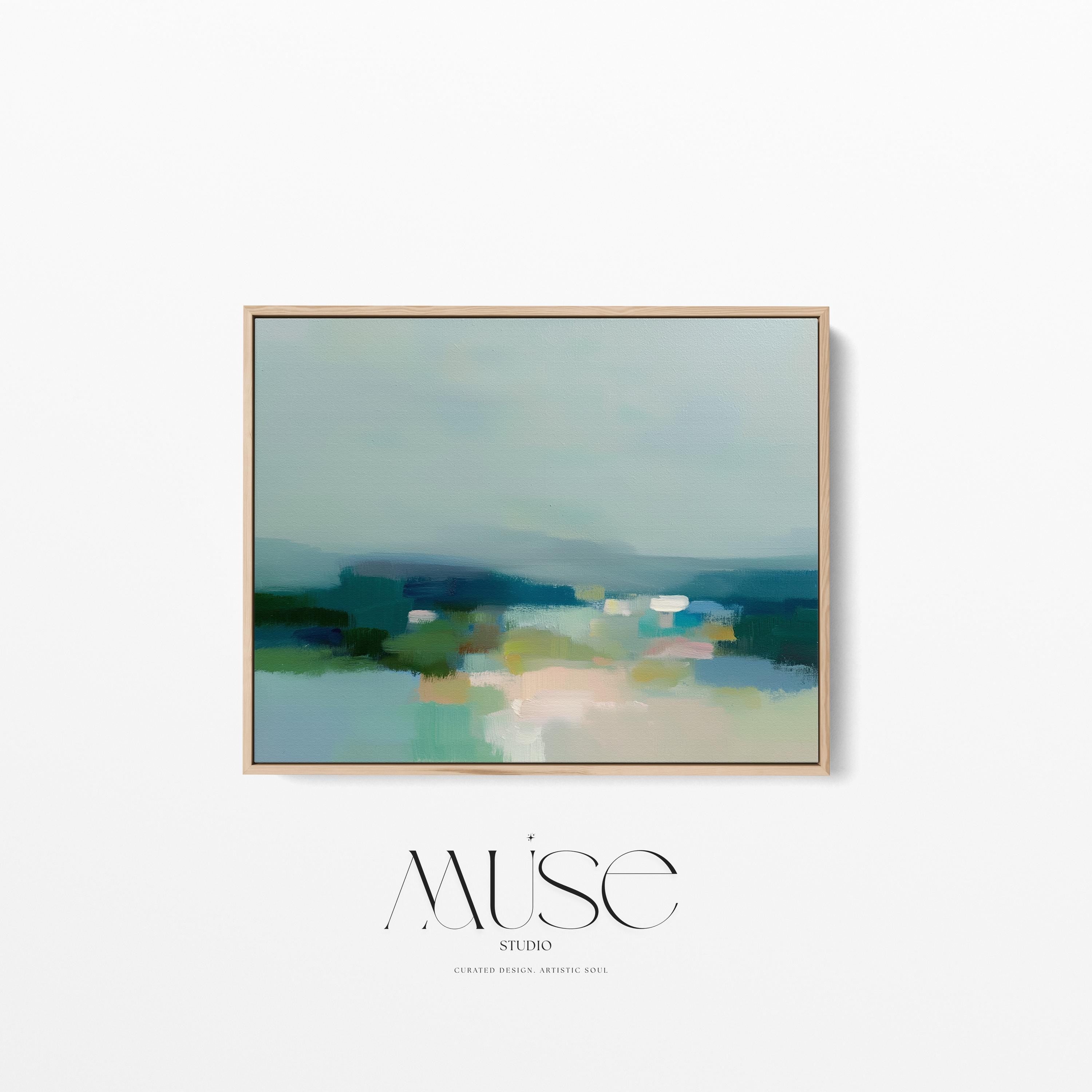 Large horizontal framed canvas wall art in sage green, deep teal, cream, and soft blue tones styled above a light wood console in a warm neutral interior, creating a calm landscape-inspired focal point.