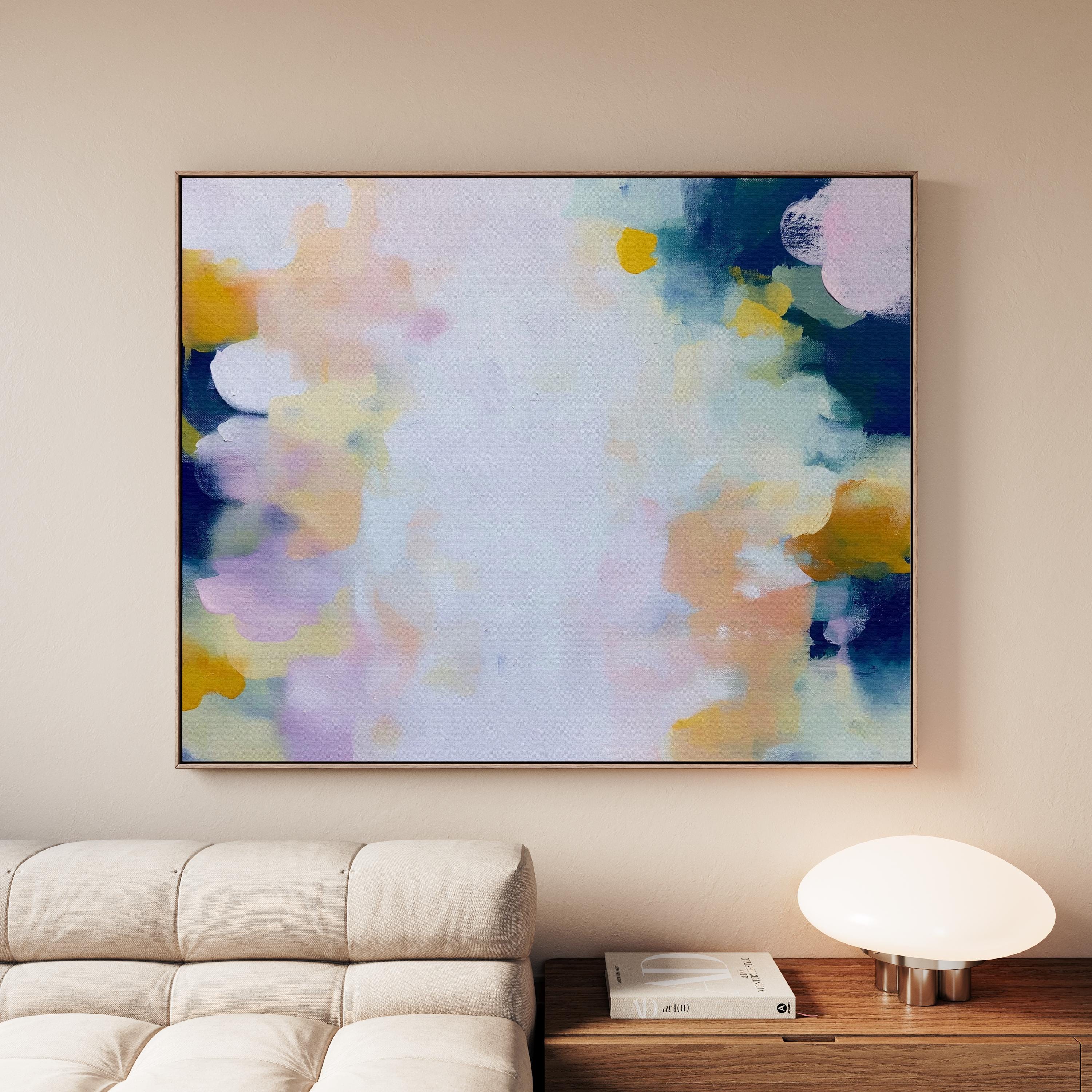 Muse Studio large horizontal framed abstract wall art printed with museum-grade giclée inks on premium gallery-wrapped canvas, featuring blush and navy pastel tones in an Organic Transitional style, styled above a linen sofa in a coastal living room.
