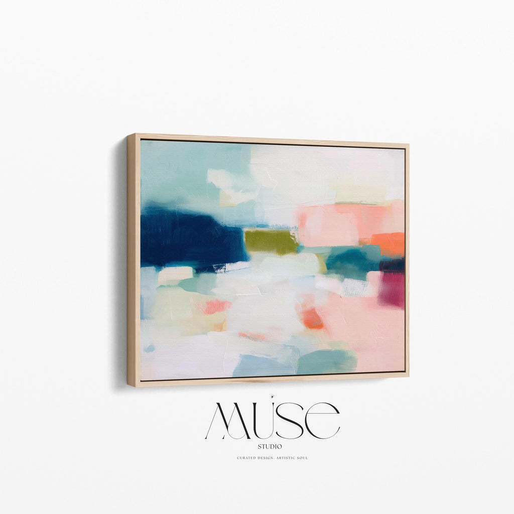 Large horizontal abstract framed canvas wall art featuring deep navy blue, muted aqua, soft blush pink, olive green, coral accents, and layered white brushstrokes, styled above a neutral sofa in a modern coastal living room, offering balanced contrast and refined contemporary color.