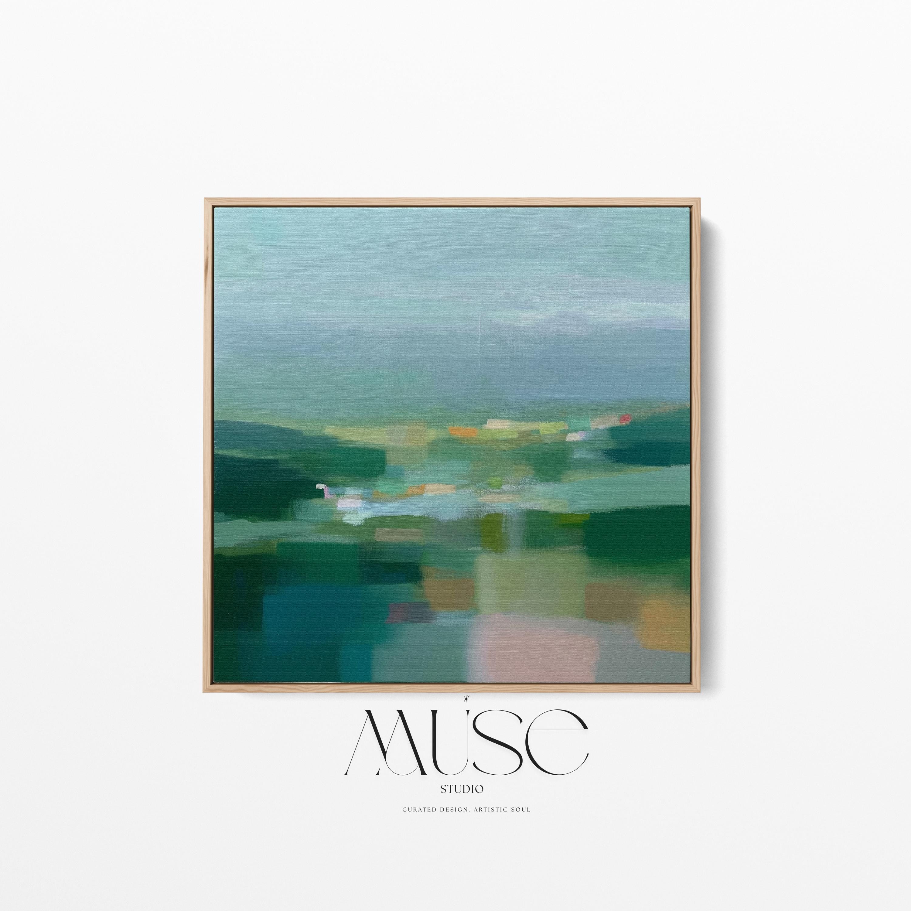Large square framed canvas wall art in layered sage, deep green, and misty blue tones styled against a light neutral wall, creating a calm nature-inspired focal point in a refined interior.