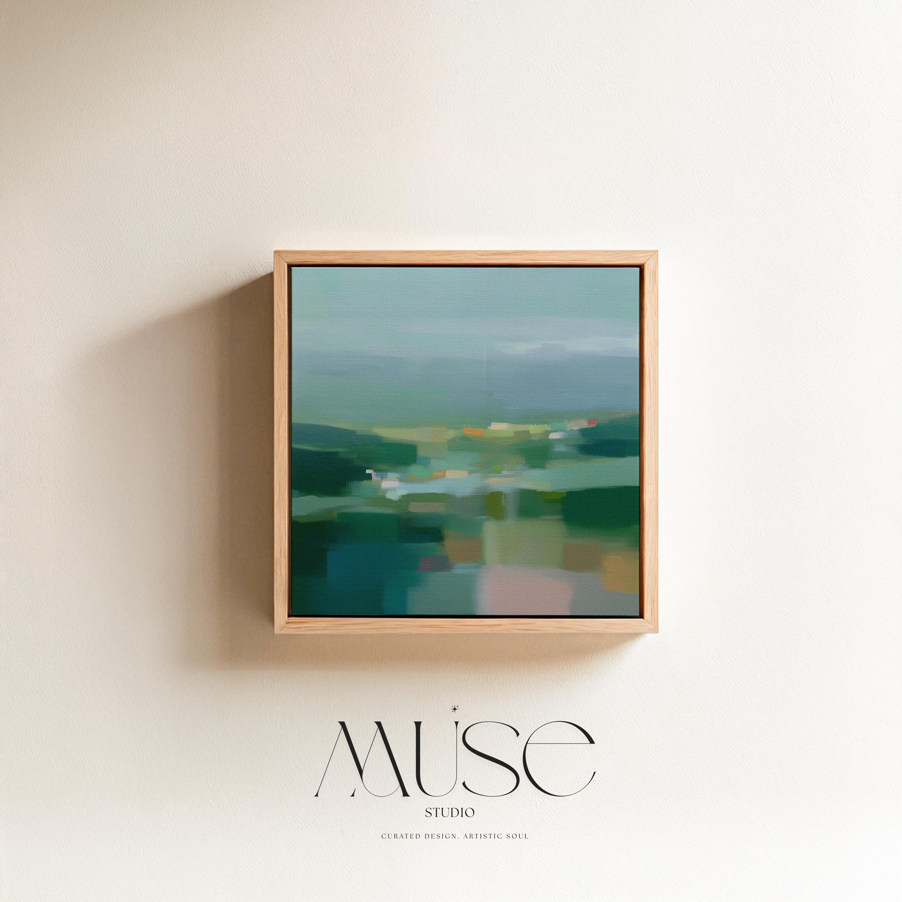Large square framed canvas wall art in layered sage, deep green, and misty blue tones styled against a light neutral wall, creating a calm nature-inspired focal point in a refined interior.